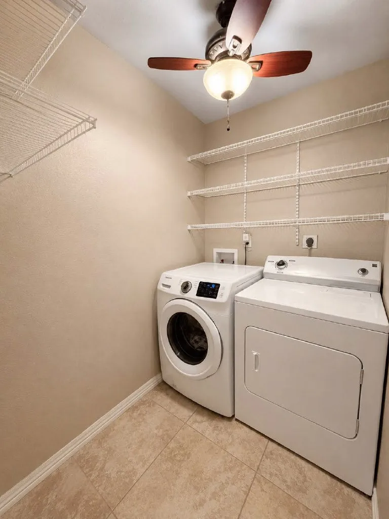 Dedicated laundry space featuring a ceiling fan with integrated lighting, tile flooring, and multiple wire shelving units