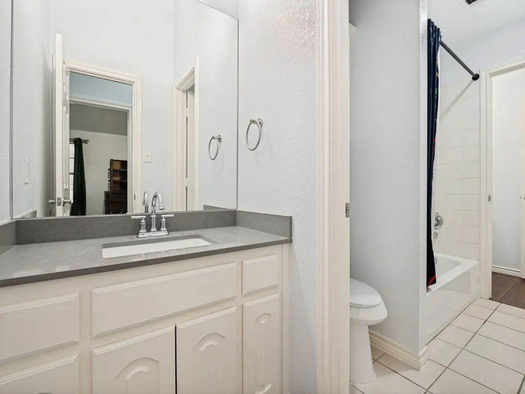 Bathroom vanity featuring a light gray countertop, undermount sink, and chrome faucet