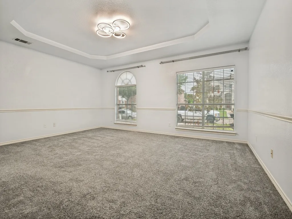 Spacious interior featuring a coffered ceiling, recessed lighting, and gray carpeting