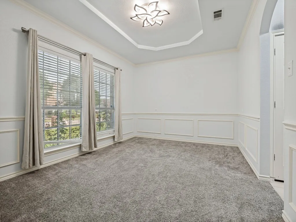 Room featuring a decorative tray ceiling with a contemporary light fixture