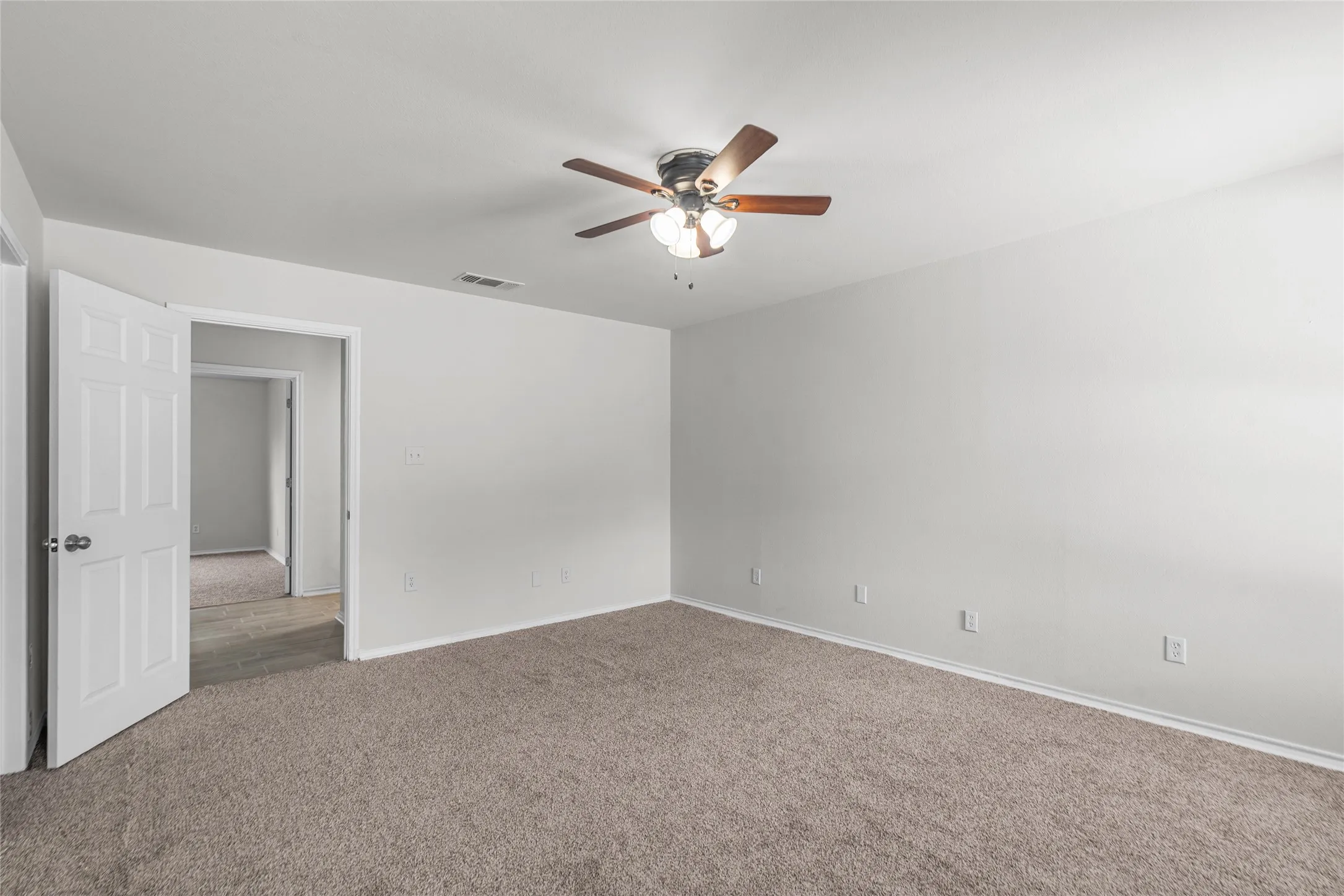 Spacious room featuring neutral carpeting and white walls