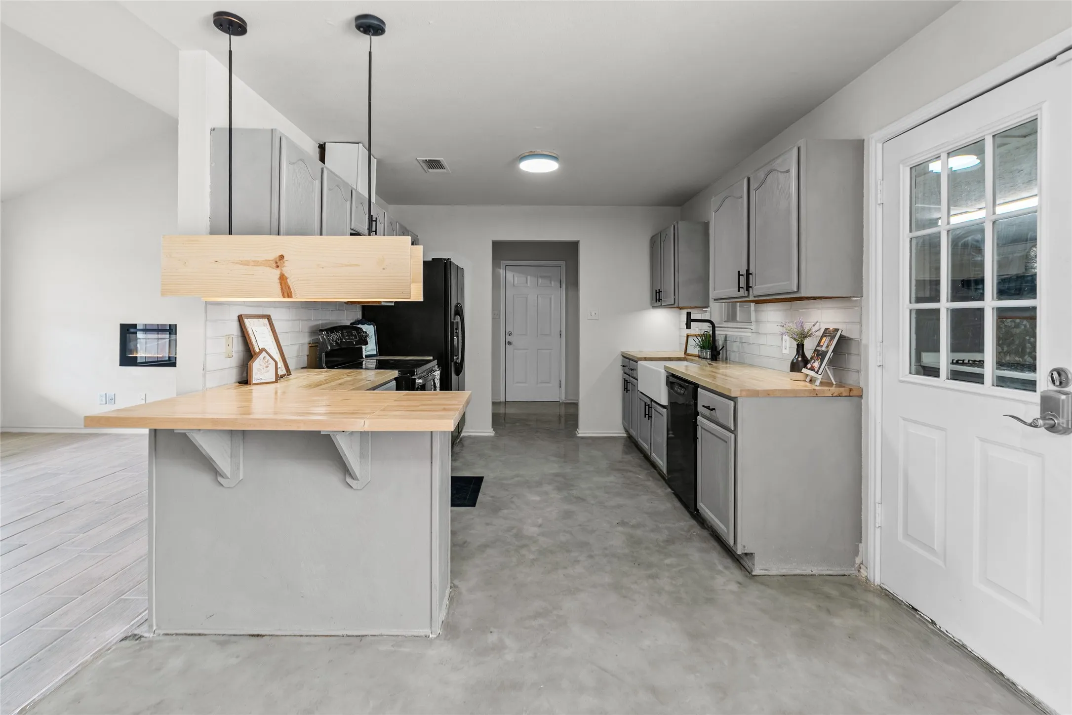 Kitchen featuring light gray cabinetry, wood-finish countertops, and a white subway tile backsplash