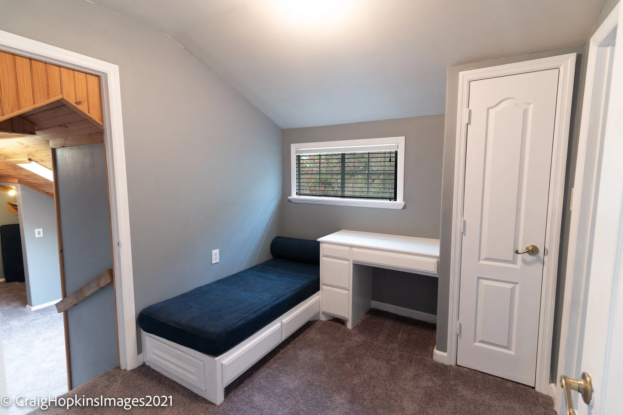 Room featuring sloped ceilings, gray wall paint, and brown carpet flooring