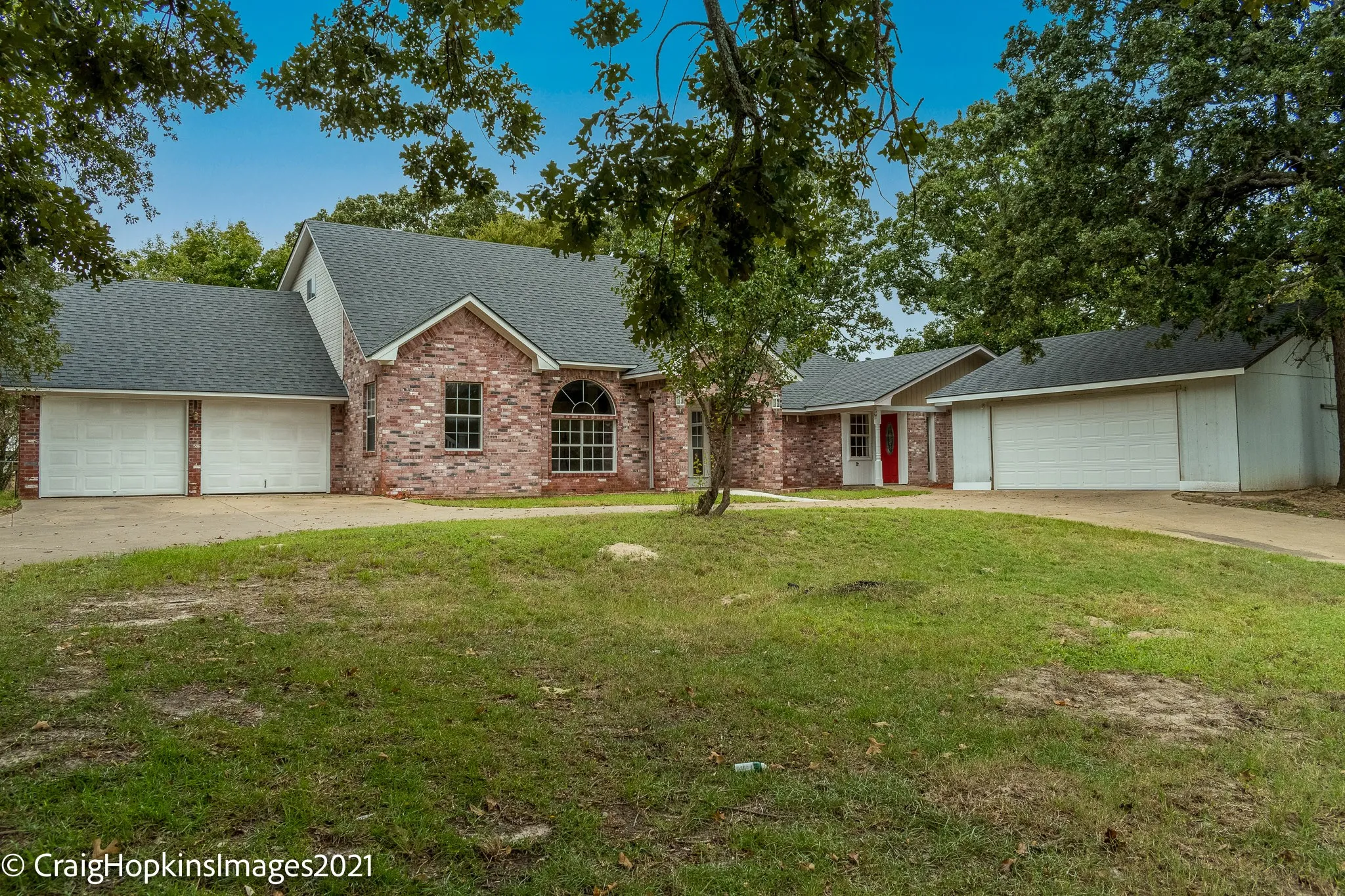 Brick exterior residence featuring a prominent arched window and a gabled roofline