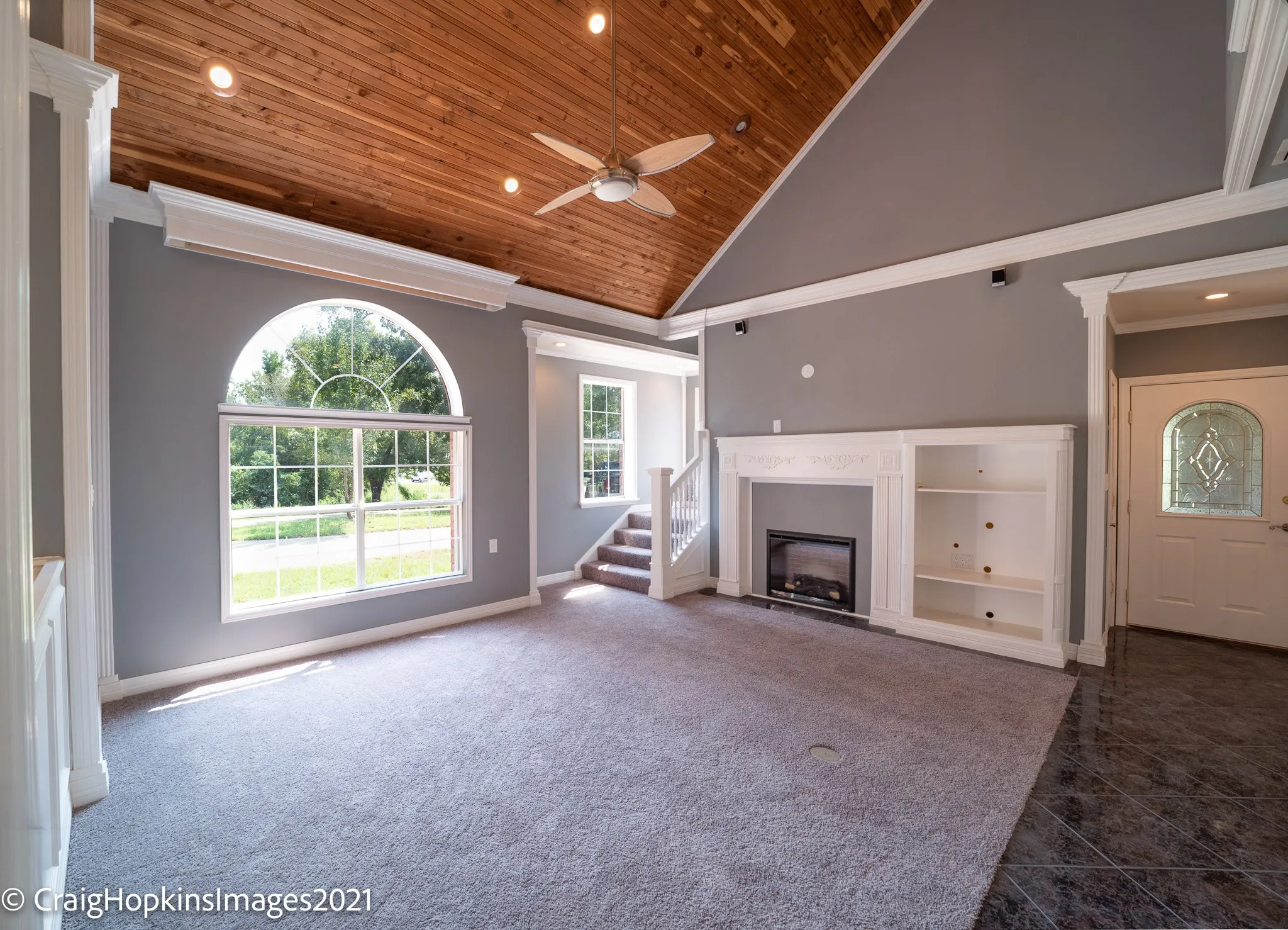 Vaulted wood-finish ceiling with recessed lighting and ceiling fan