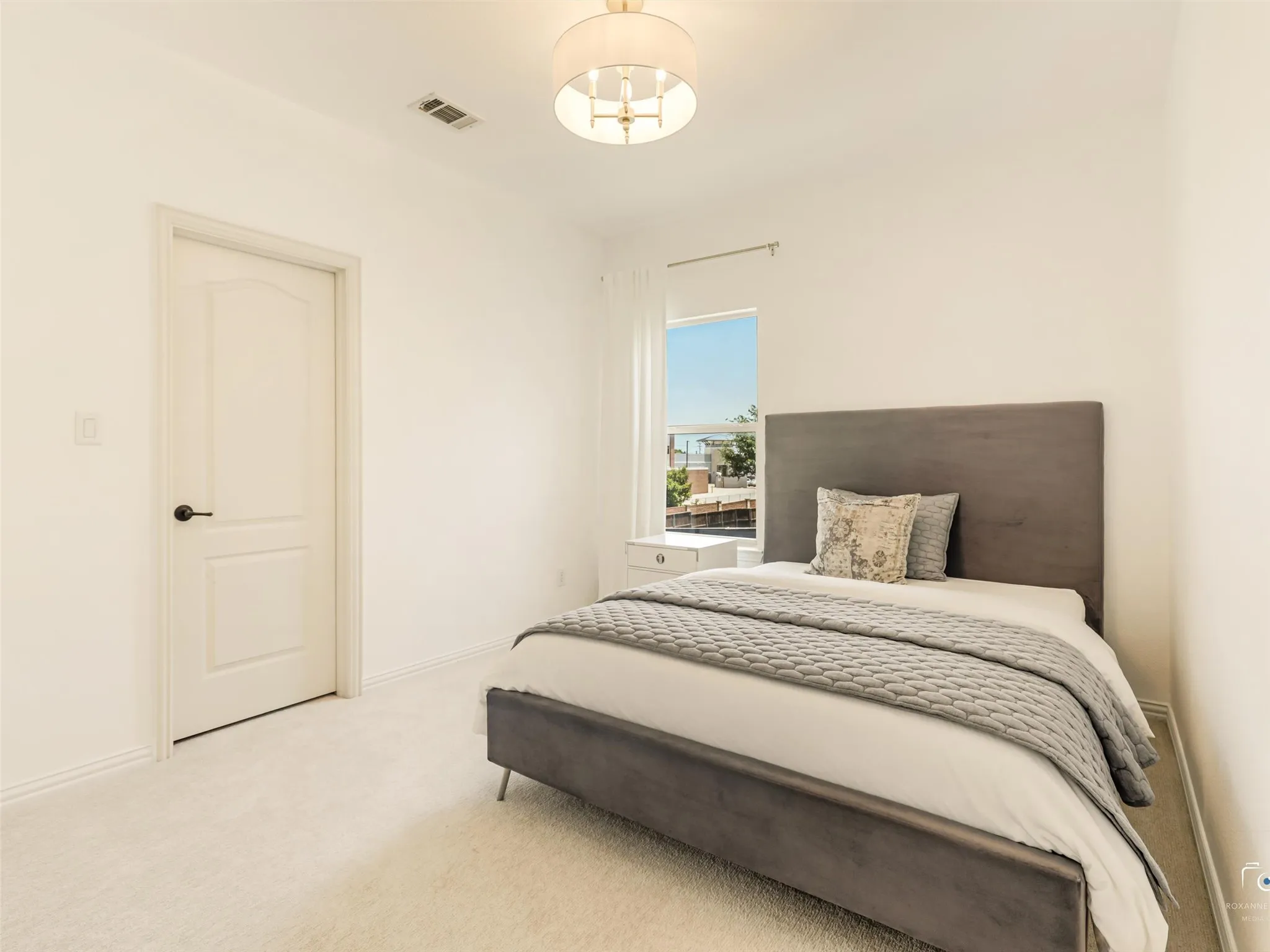Bright secondary bedroom offers generous space, plush carpet, and large windows, making it ideal for family members or overnight guests.