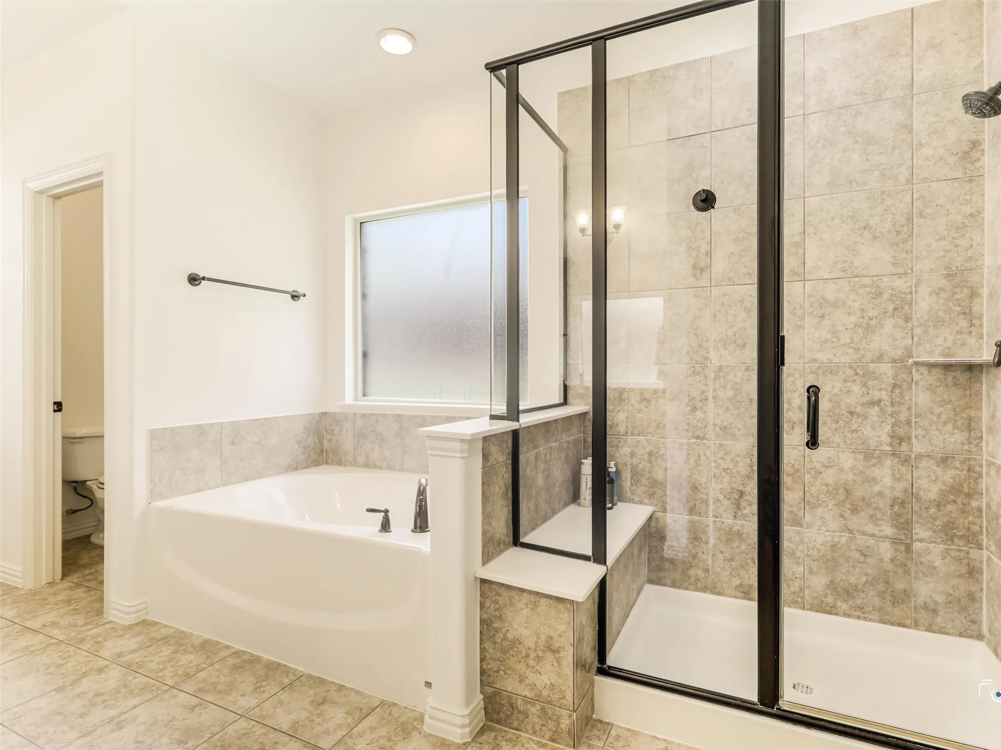 Luxurious ensuite features dual sinks, expansive granite countertops, generous cabinetry, and direct access to the oversized shower and soaking tub.