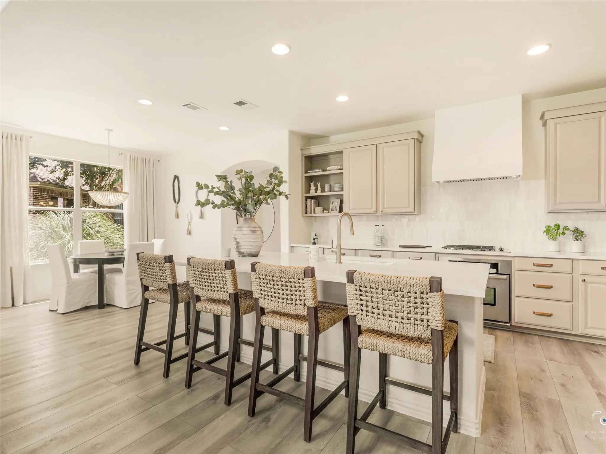 Oversized island with seating anchors the heart of the home and opens to the dining area and family room.