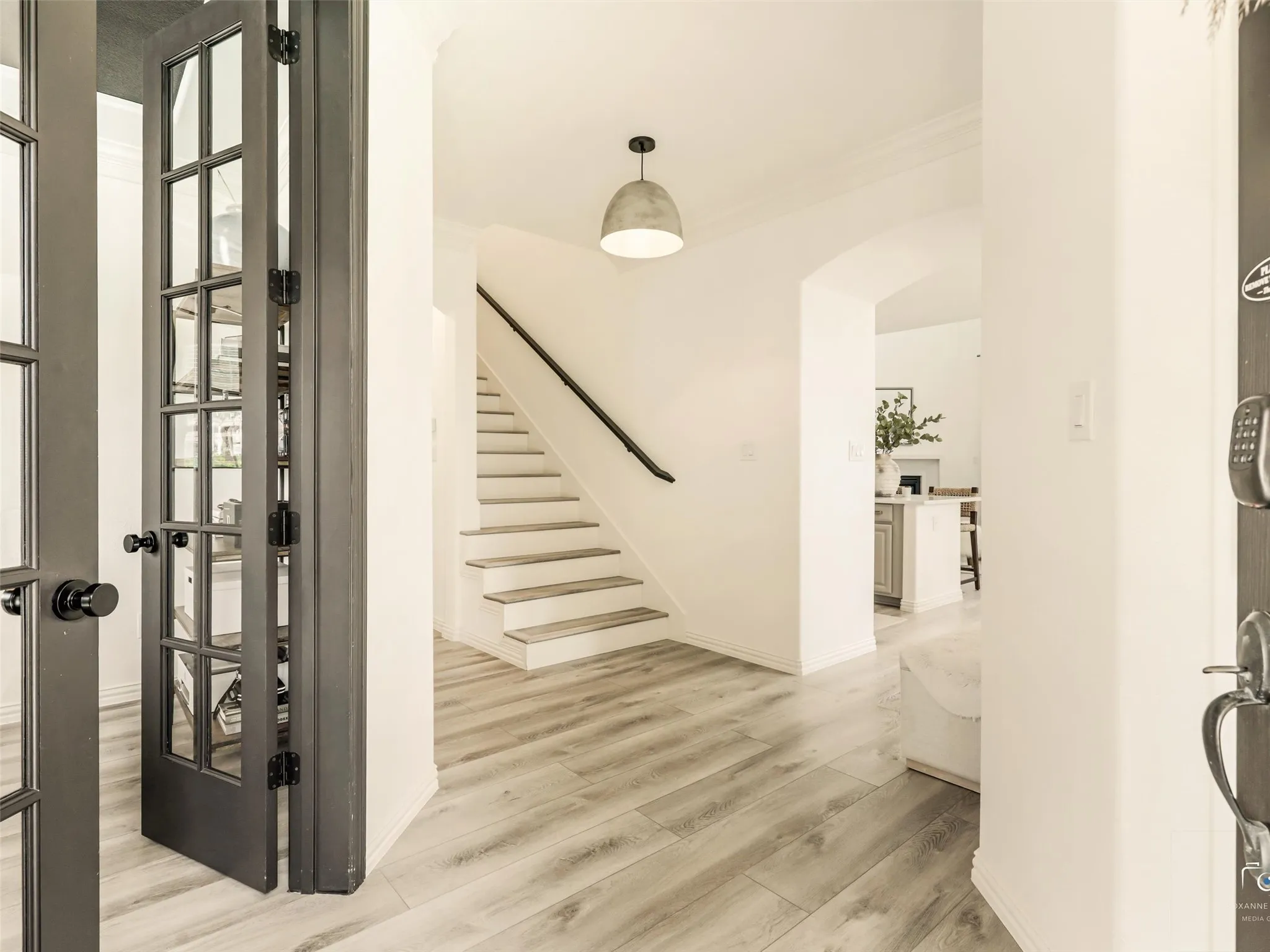 Walk into this light-filled entry that welcomes you with luxury vinyl plank flooring, designer lighting, and an upgraded staircase.