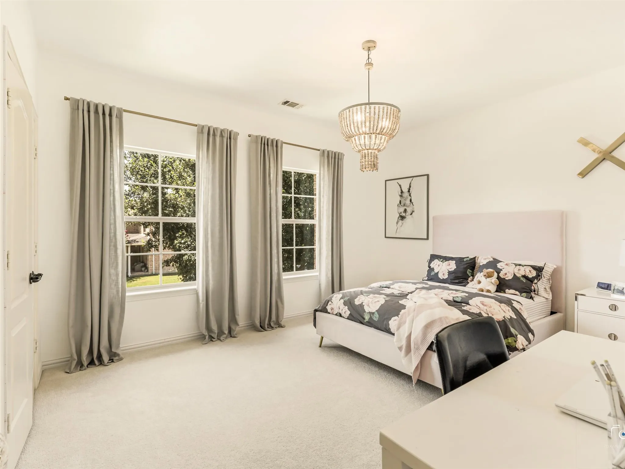 Charming secondary bedroom features abundant natural light and ample room for a full bedroom suite or home office setup.