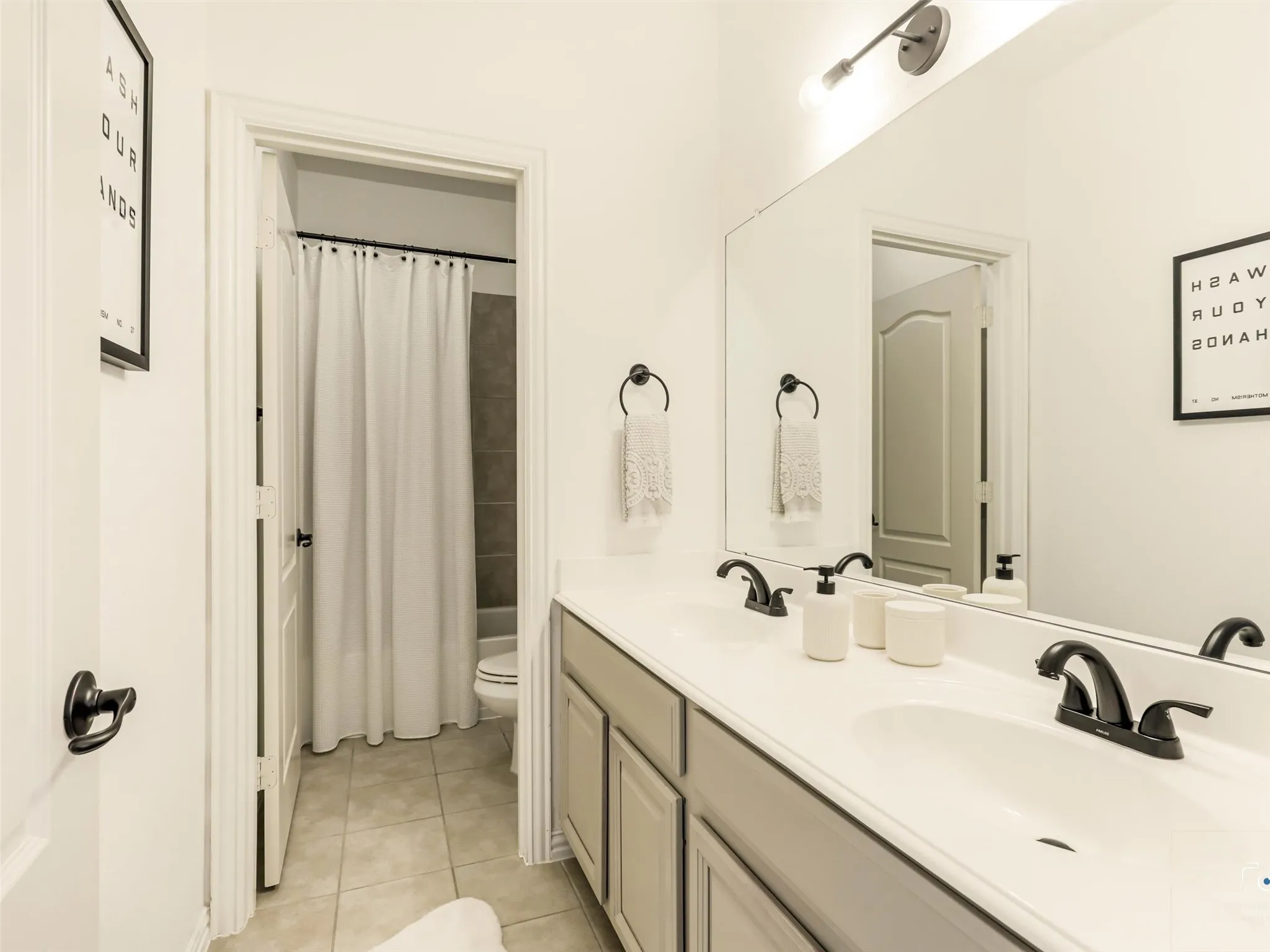 Well-appointed secondary bath includes an extended vanity with generous counter space and a private tub/shower area for added convenience.
