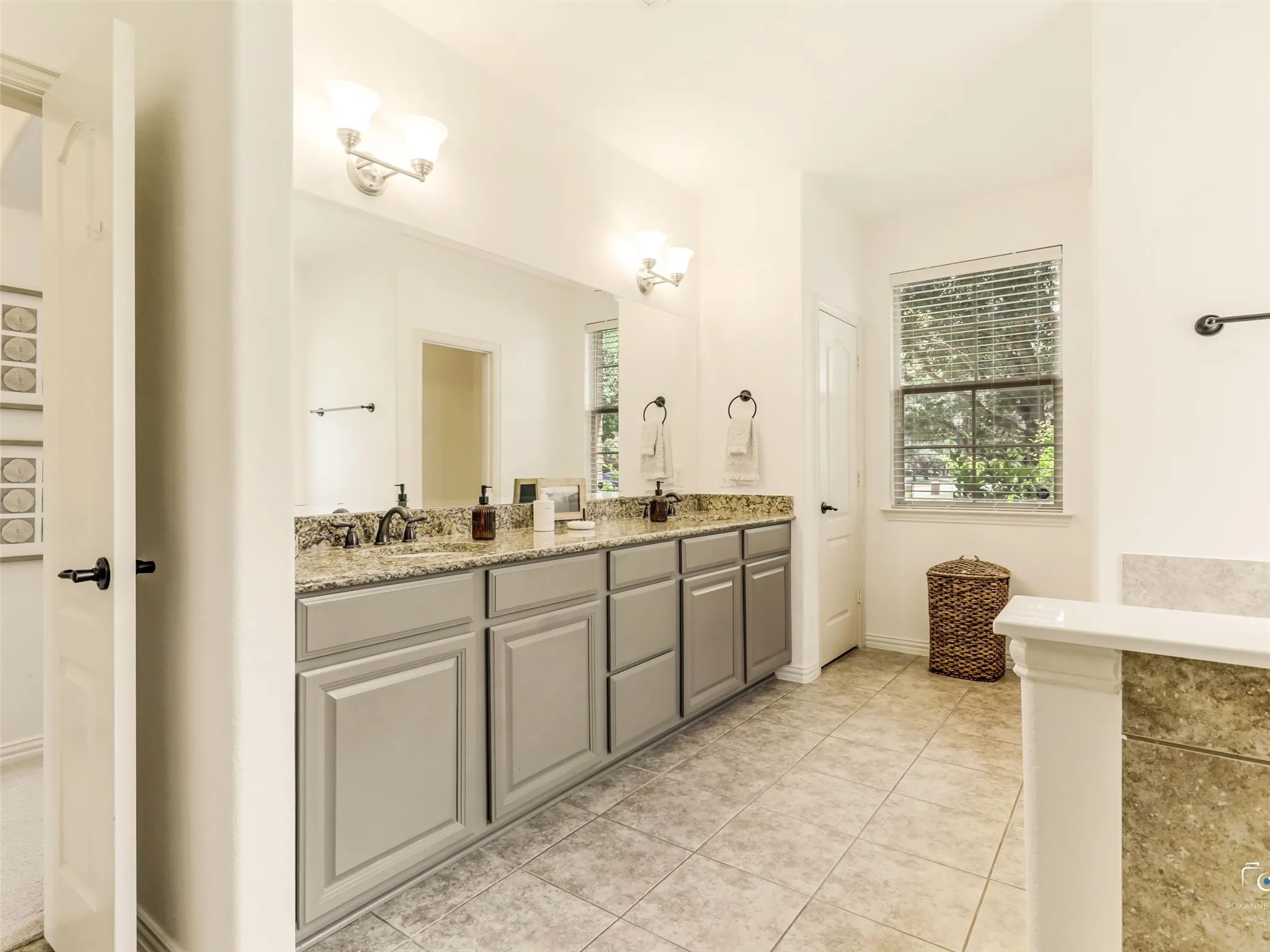 Spa-inspired primary bath boasts a relaxing garden tub, oversized walk-in shower, and timeless tile finishes for the perfect place to unwind.
