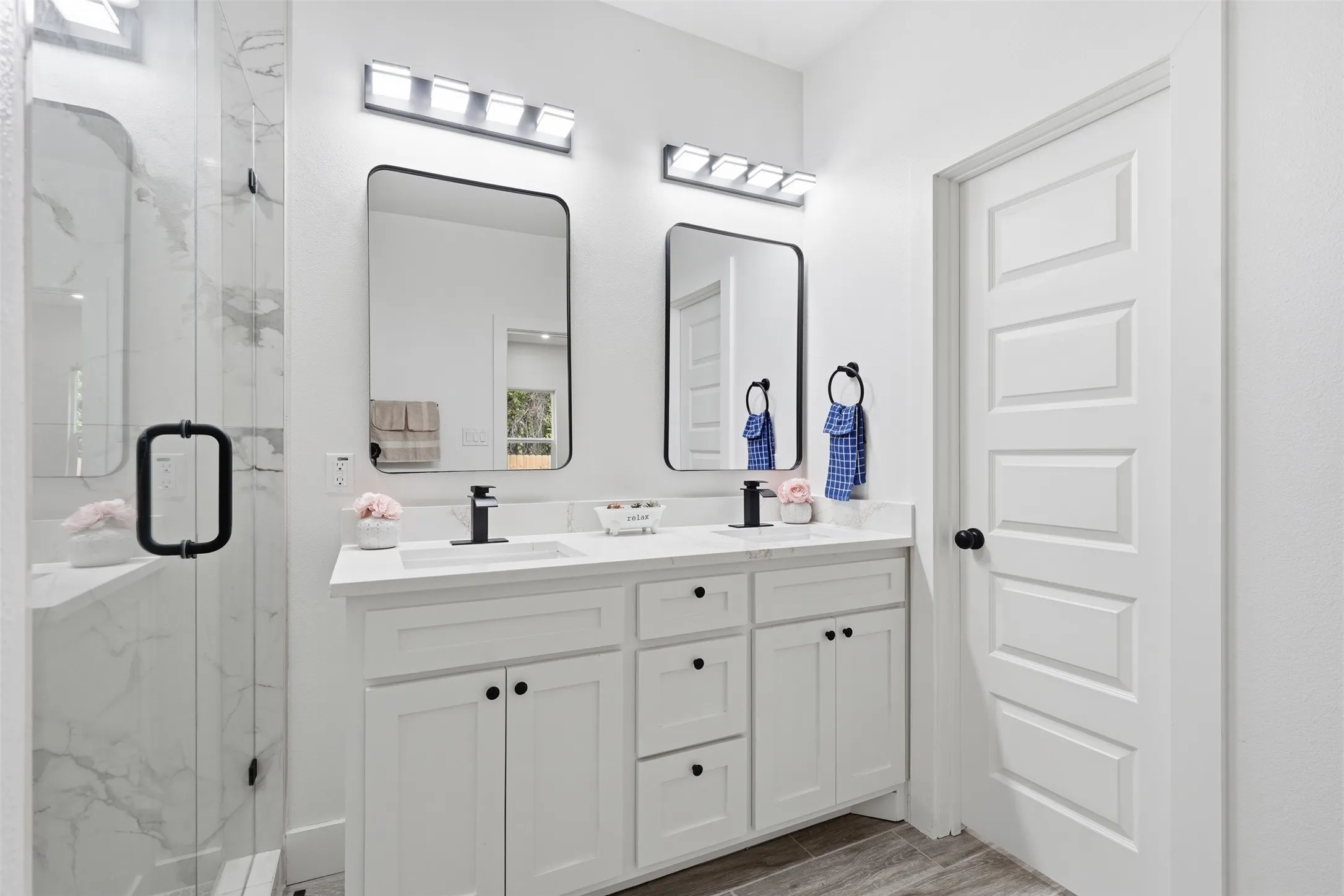 Dual vanity with white cabinetry, matte black hardware, and rectangular mirrors