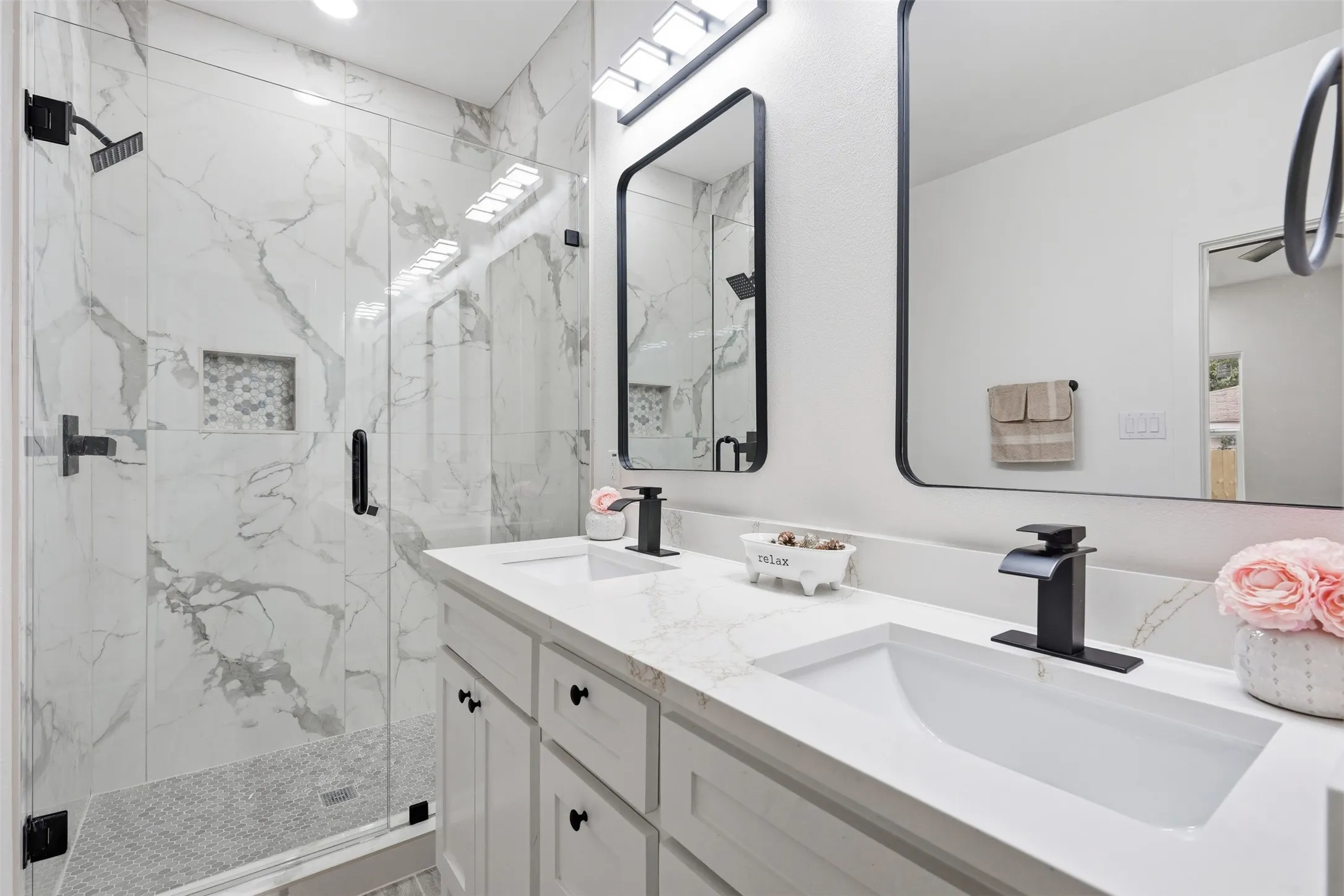 Dual vanity featuring integrated rectangular sinks, matte black faucets, and white quartz countertops