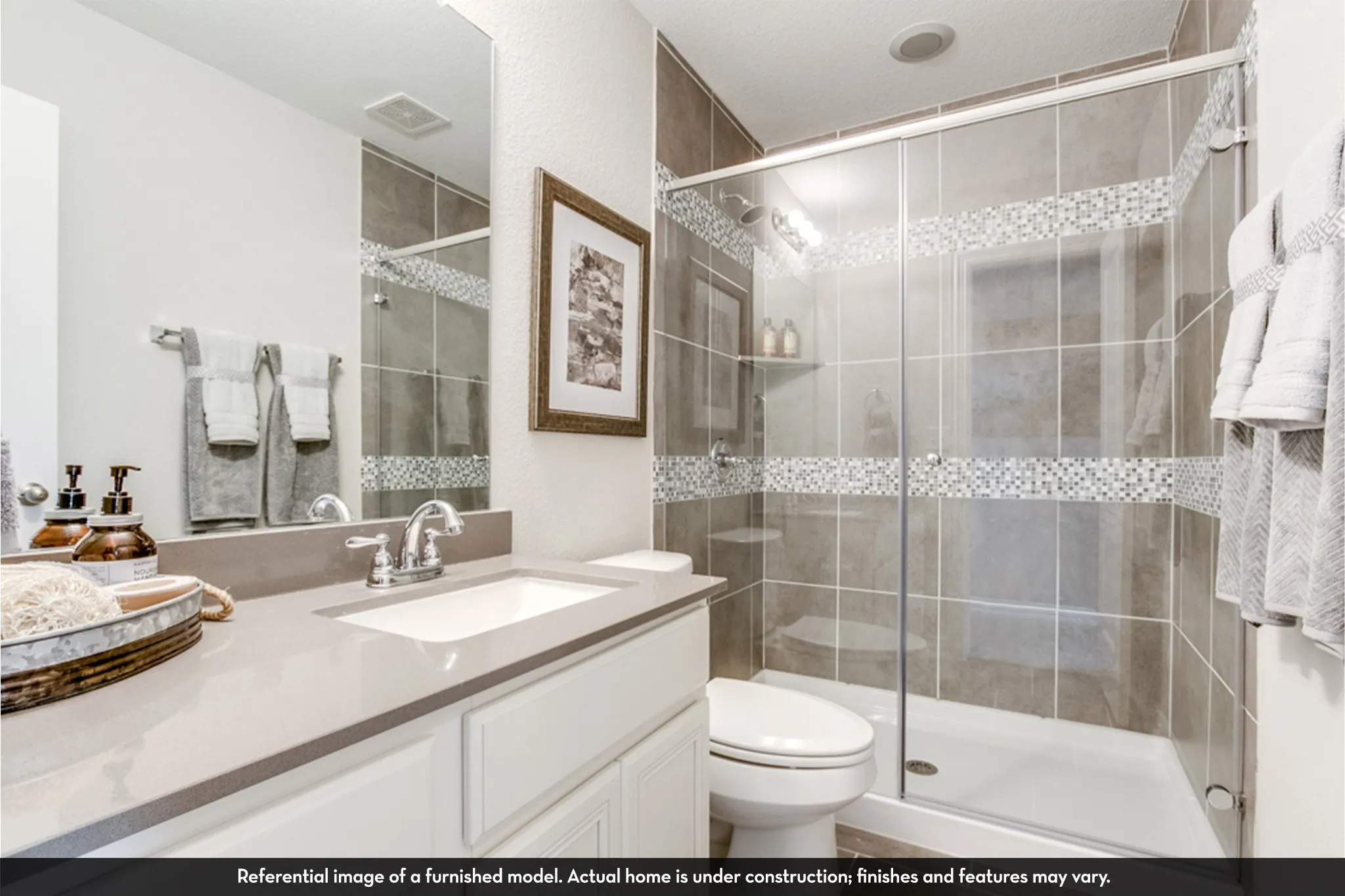 Bathroom featuring a glass-enclosed shower with tile surround and decorative mosaic accents