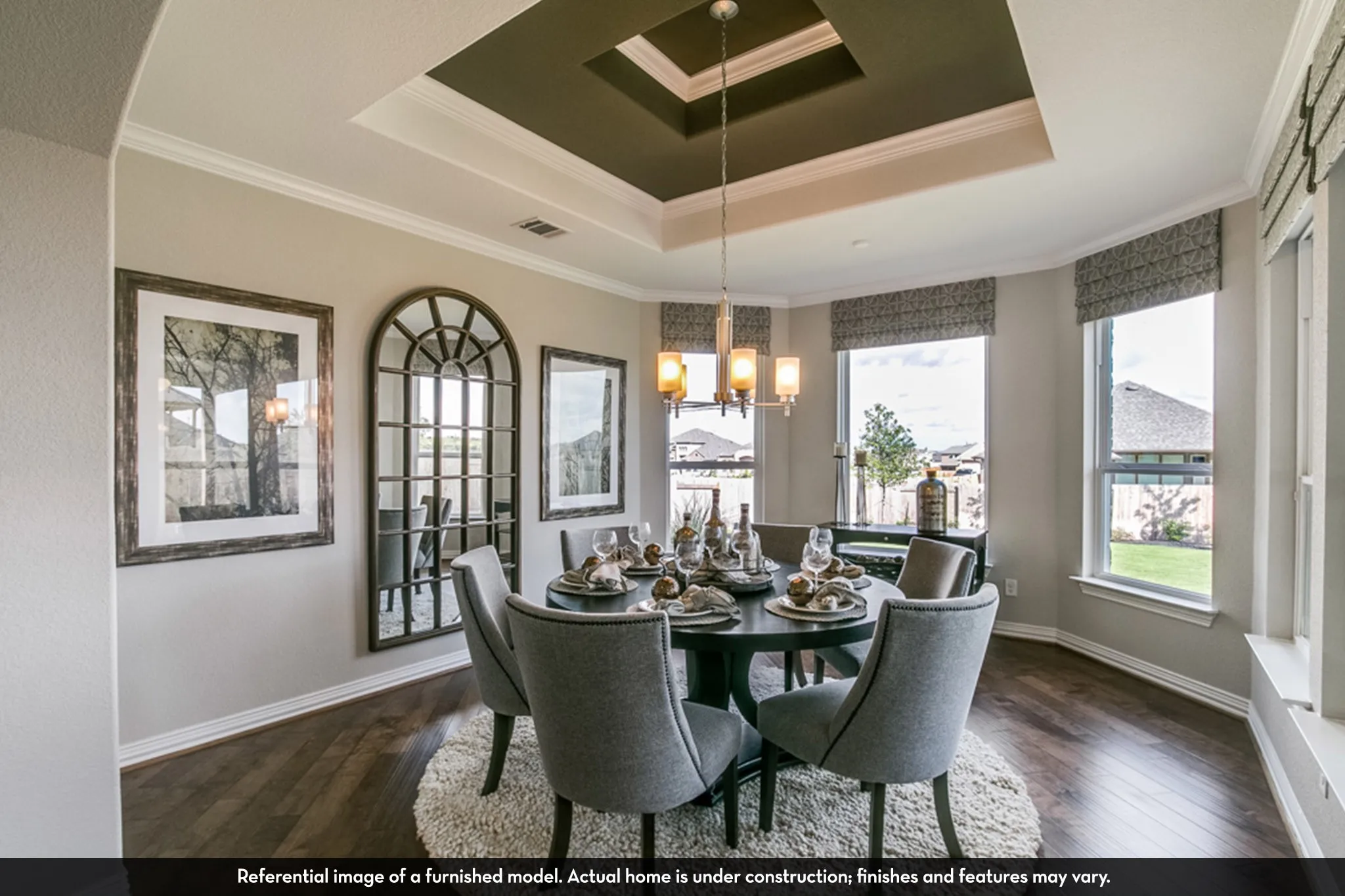 Formal dining space featuring a tray ceiling with crown molding, wood-finish flooring, and multiple windows