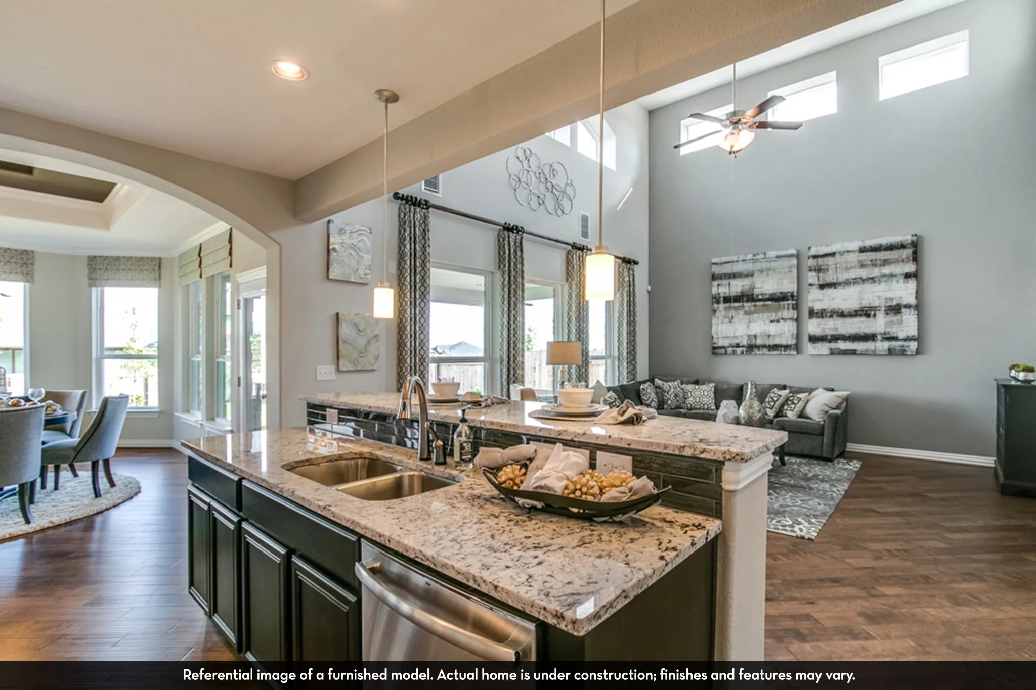 Kitchen island with granite countertops, undermount stainless steel sink, and pendant lighting