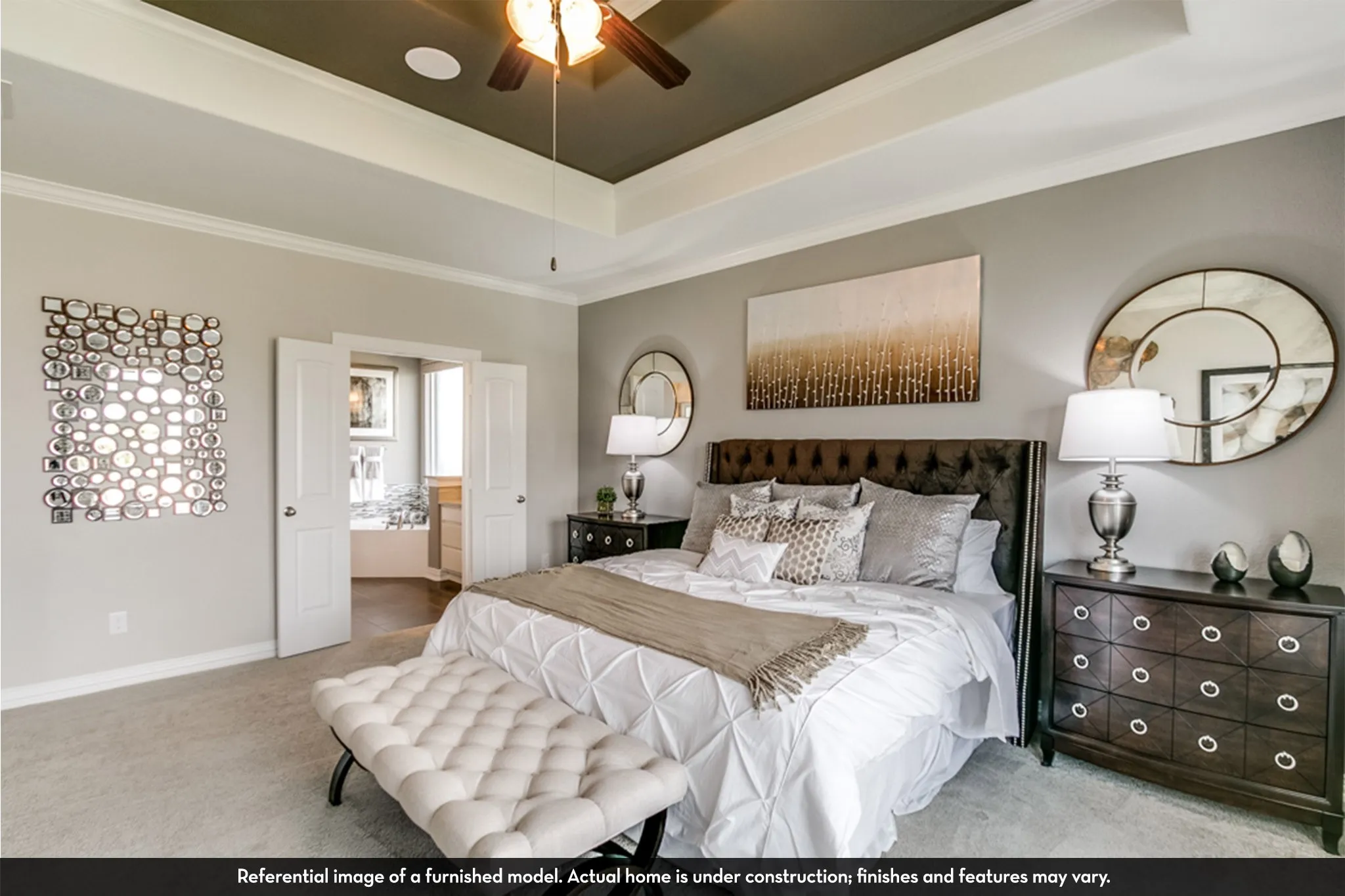 Expansive bedroom featuring a tray ceiling with a ceiling fan, carpet flooring, double doors, and crown molding
