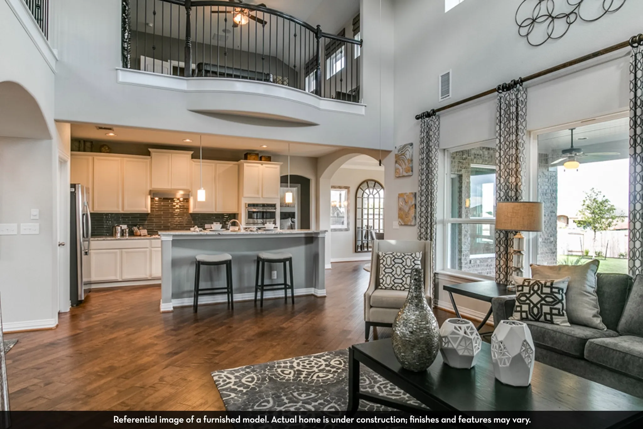Open-concept living area with wood-finish flooring, a two-story ceiling, and large windows