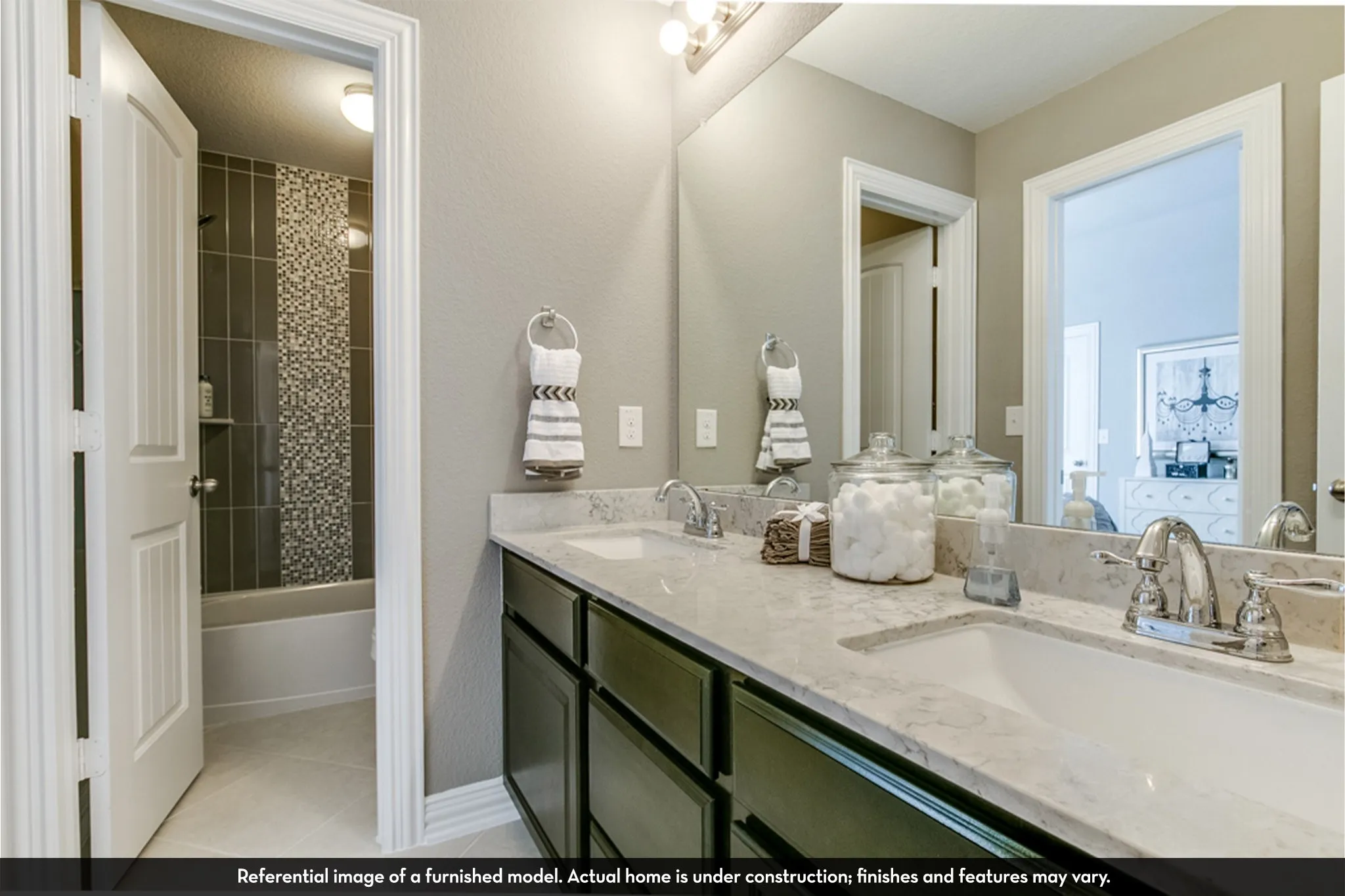 Dual vanity featuring undermount sinks, chrome faucets, and stone-finish countertops