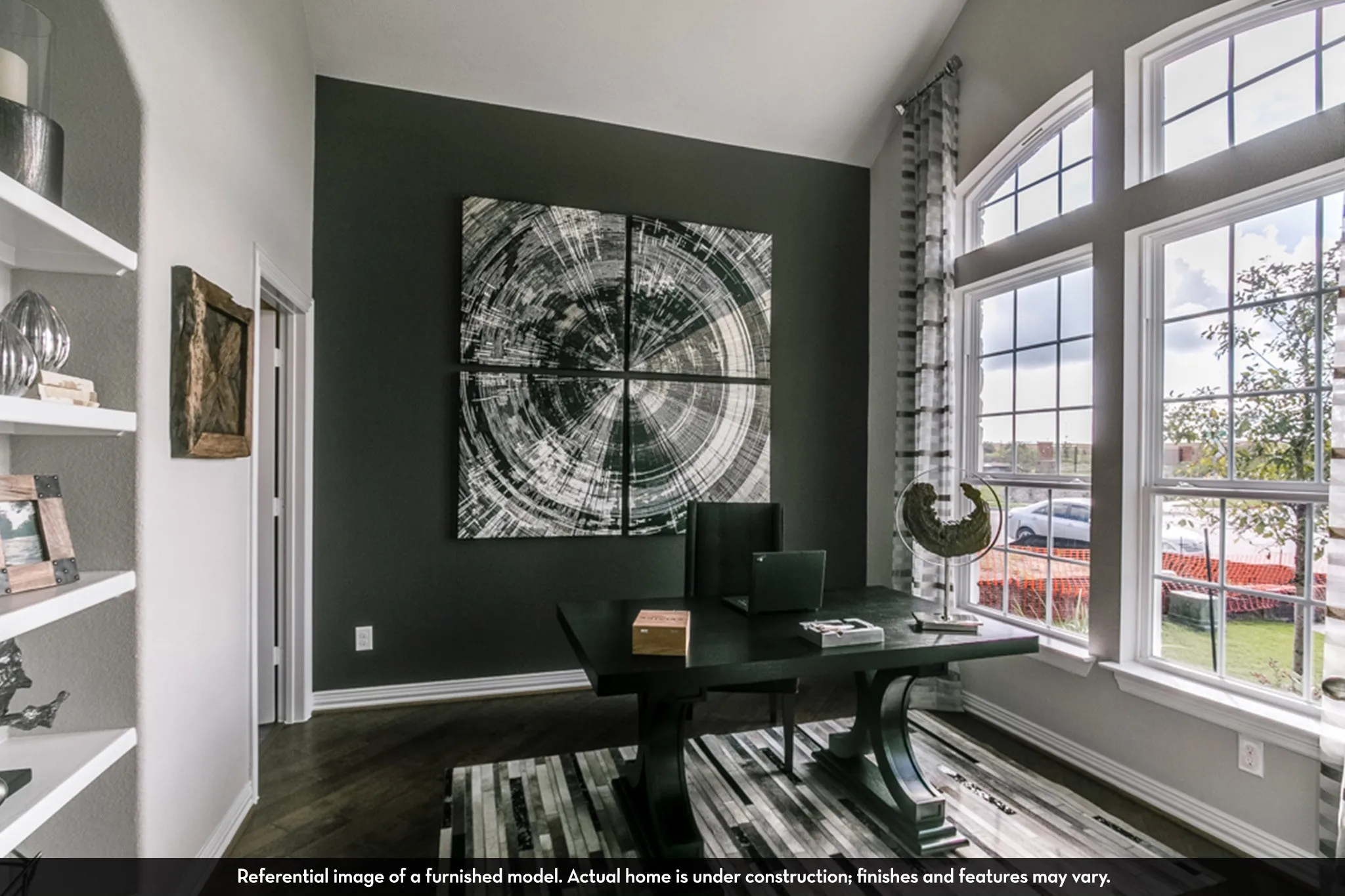 Spacious room featuring wood-finish flooring, a tall arched window, white trim, and a prominent accent wall
