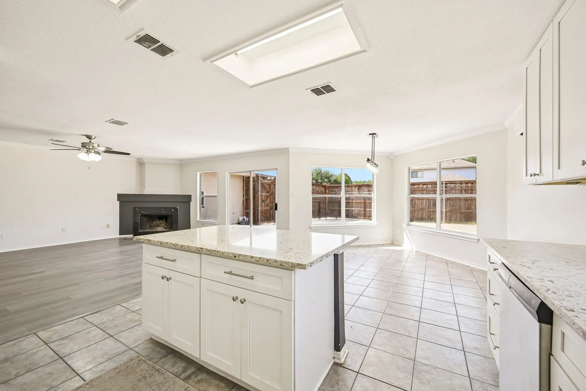 Kitchen island with a light-toned countertop, white cabinetry, and a tile floor