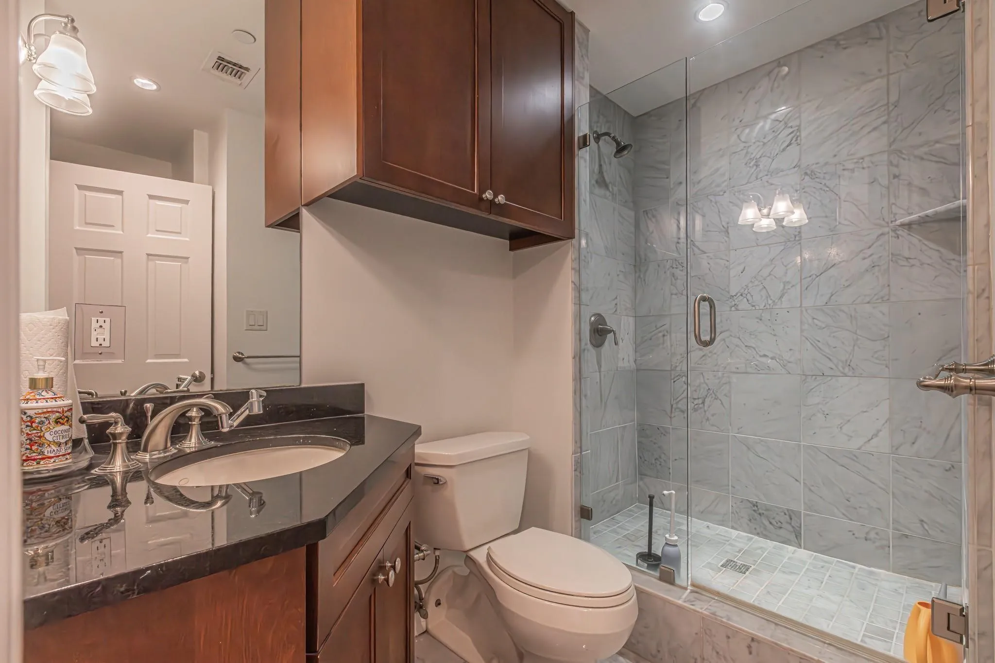 Contemporary bathroom featuring a glass-enclosed shower with tiled walls and flooring