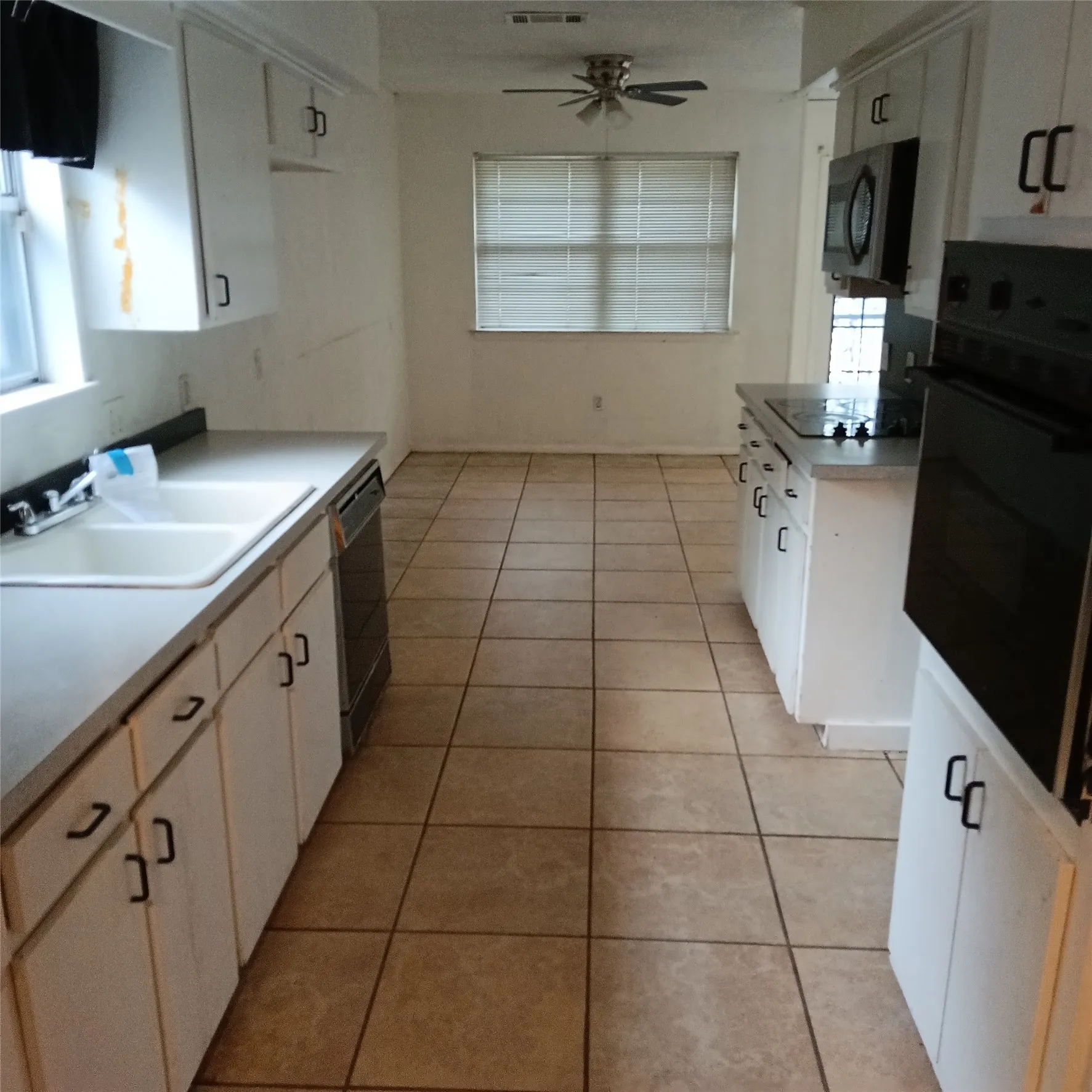 Kitchen with tile flooring and white cabinetry