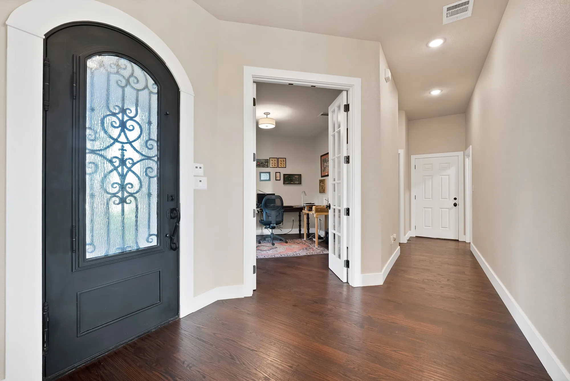 Arched entry door with decorative glass and wrought iron detailing