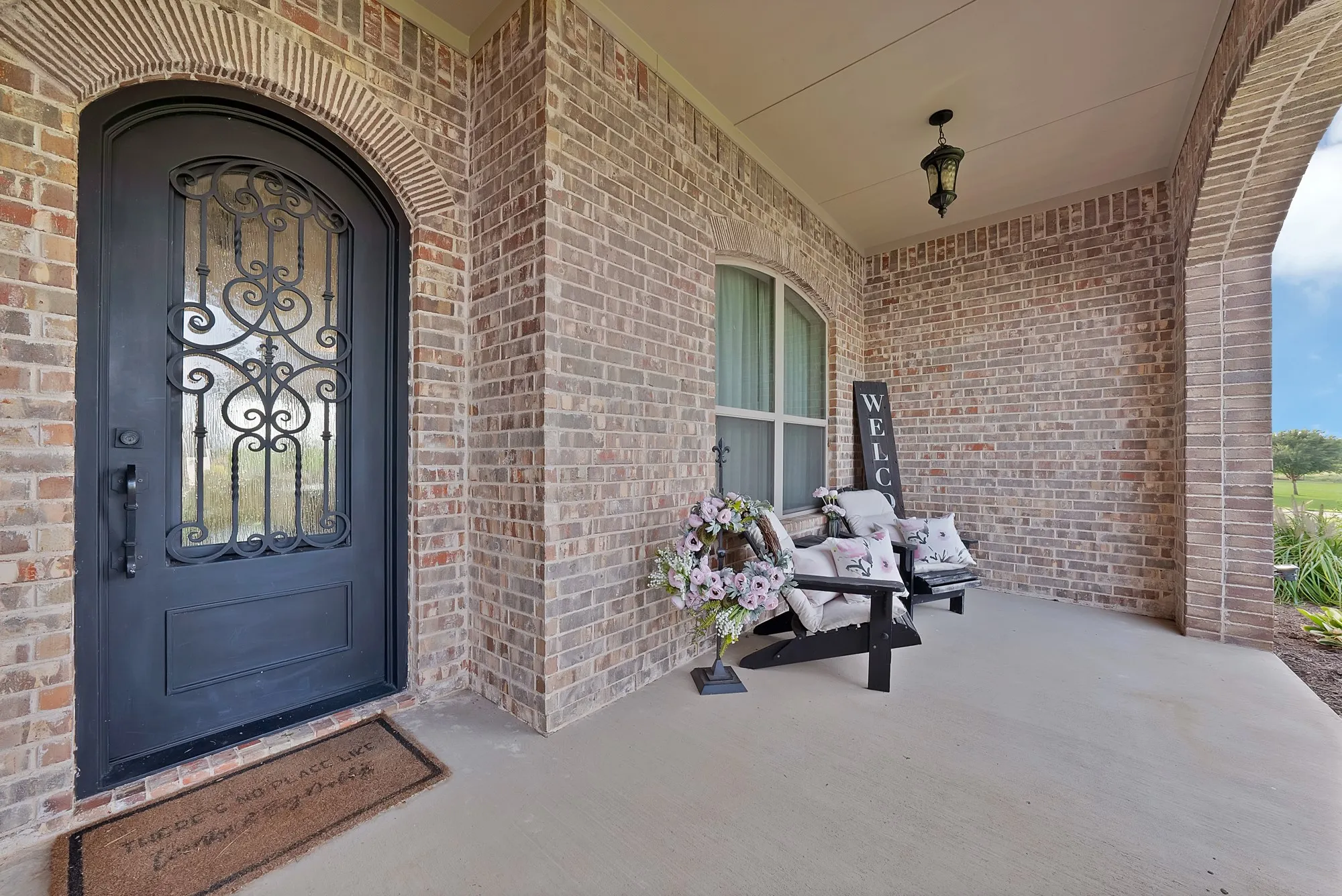 Arched entryway featuring a decorative iron and glass front door