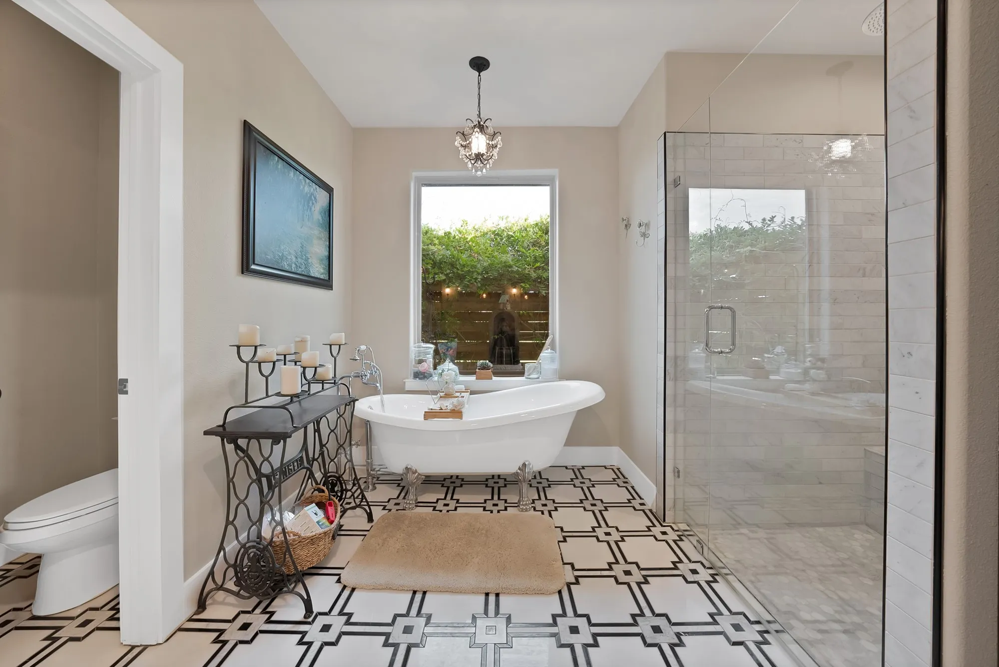 Bathroom featuring a freestanding clawfoot tub, patterned floor tiles, and a walk-in glass shower enclosure with subway tile surround