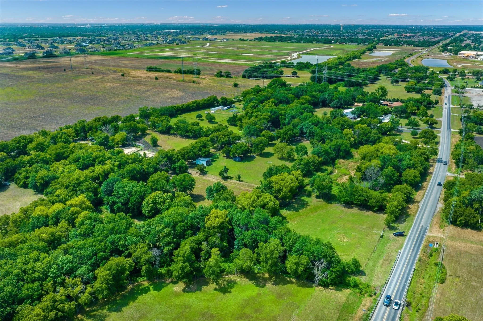 Expansive green landscape featuring mature trees and open fields