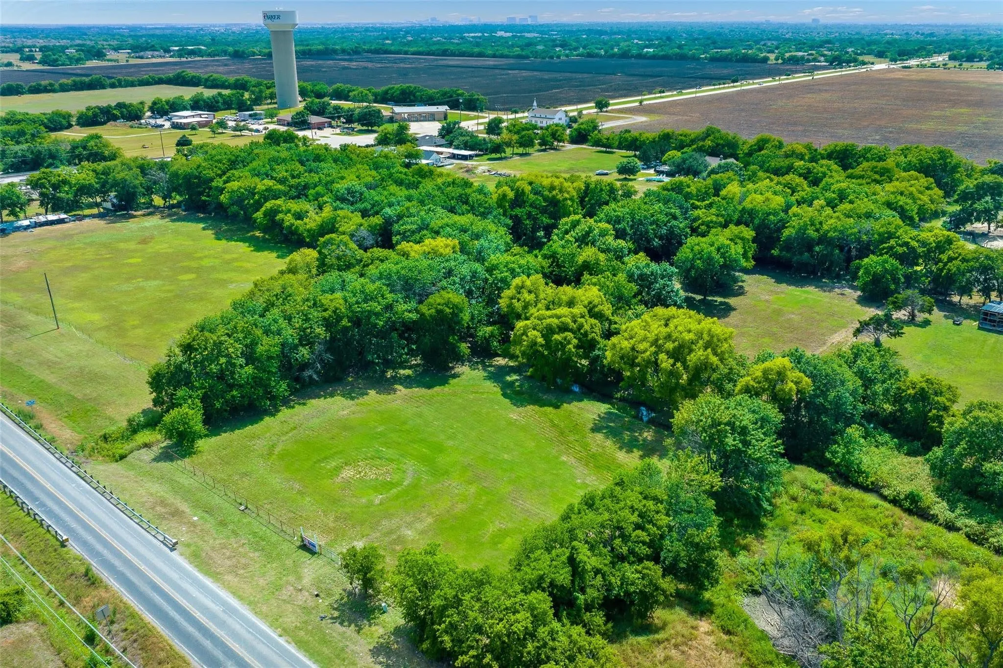 Expansive green acreage featuring mature trees and open fields