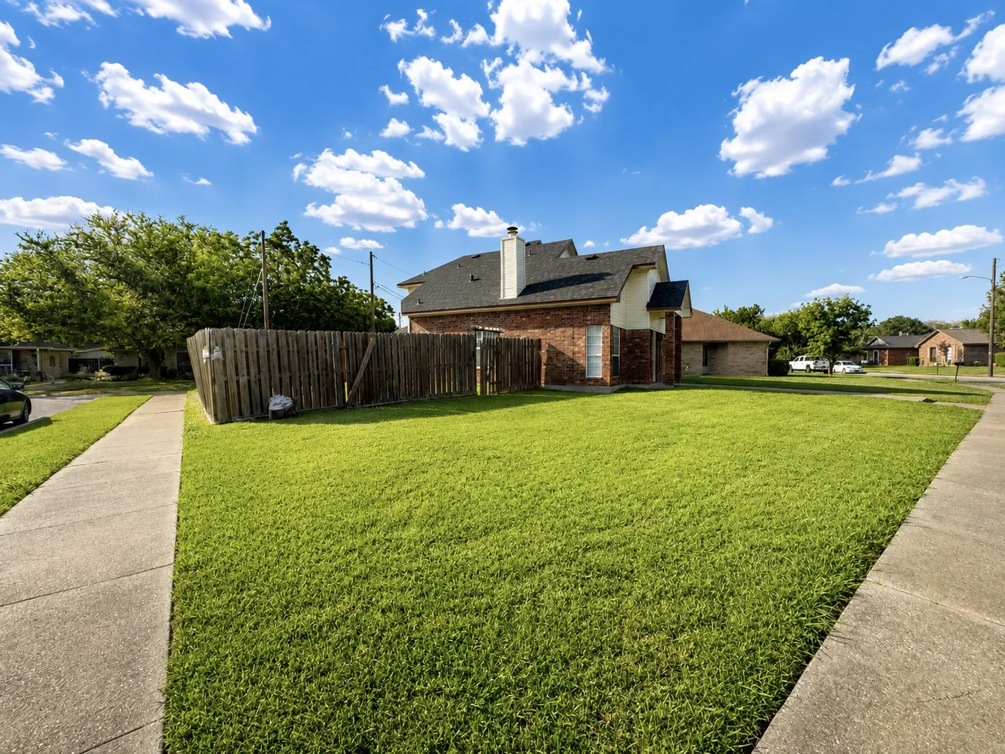 Expansive lawn area with a concrete sidewalk