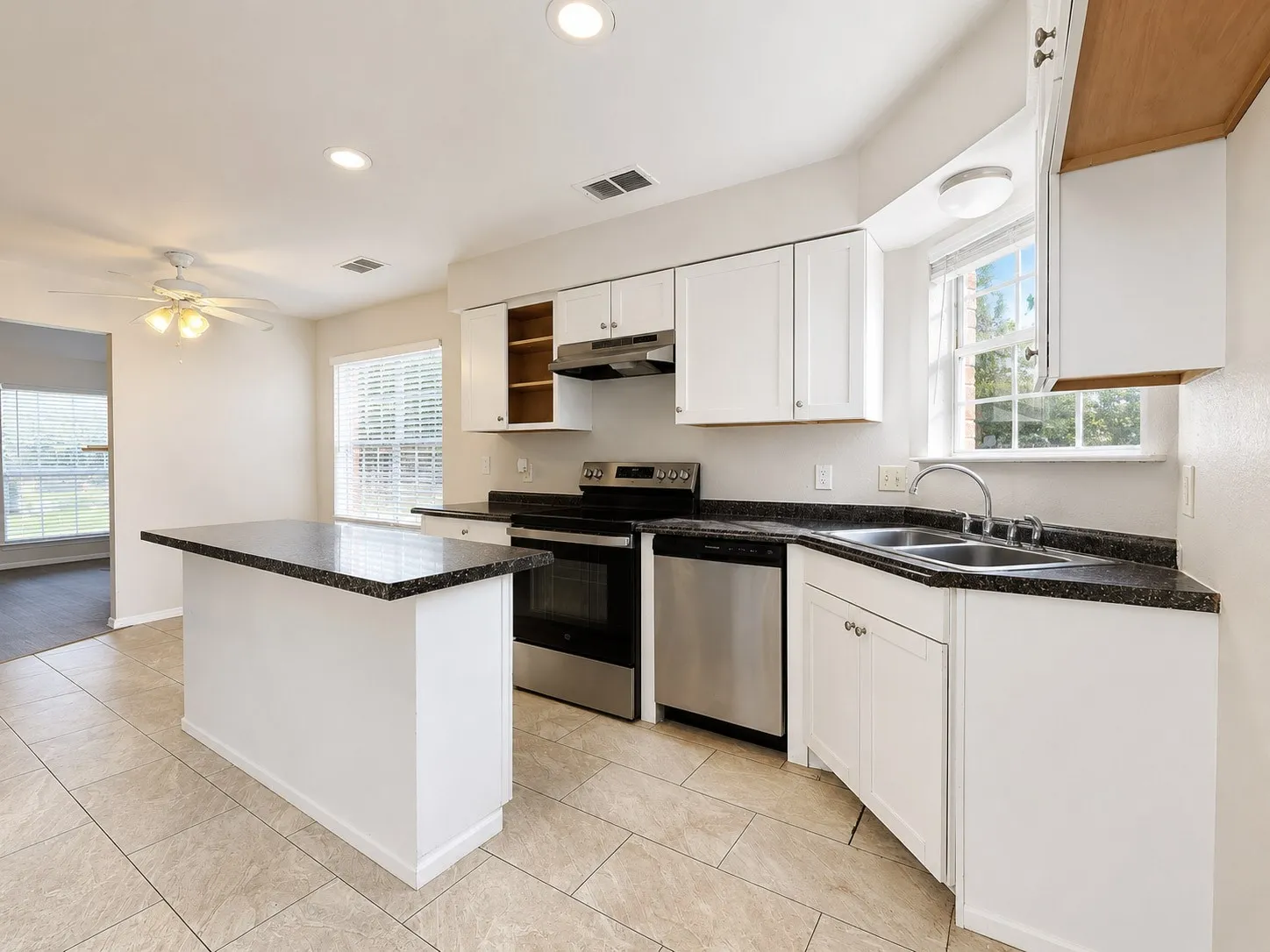 Kitchen featuring a central island with a dark countertop, white cabinetry, and stainless steel appliances