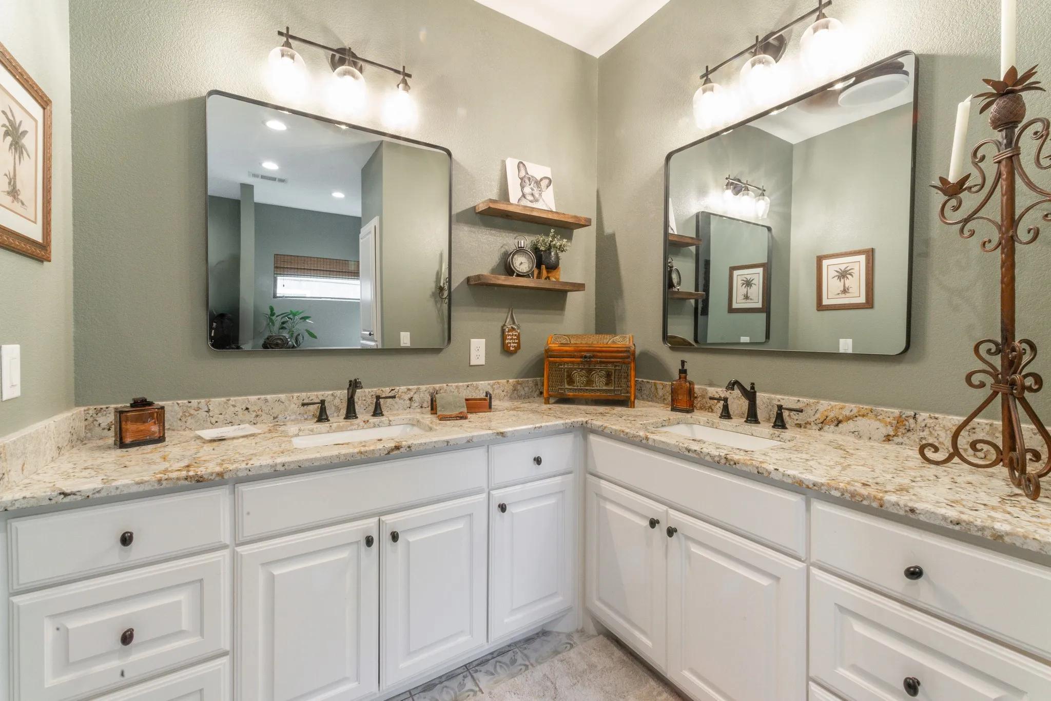 Dual vanity featuring granite countertops, white cabinetry, undermount sinks, and oil-rubbed bronze fixtures