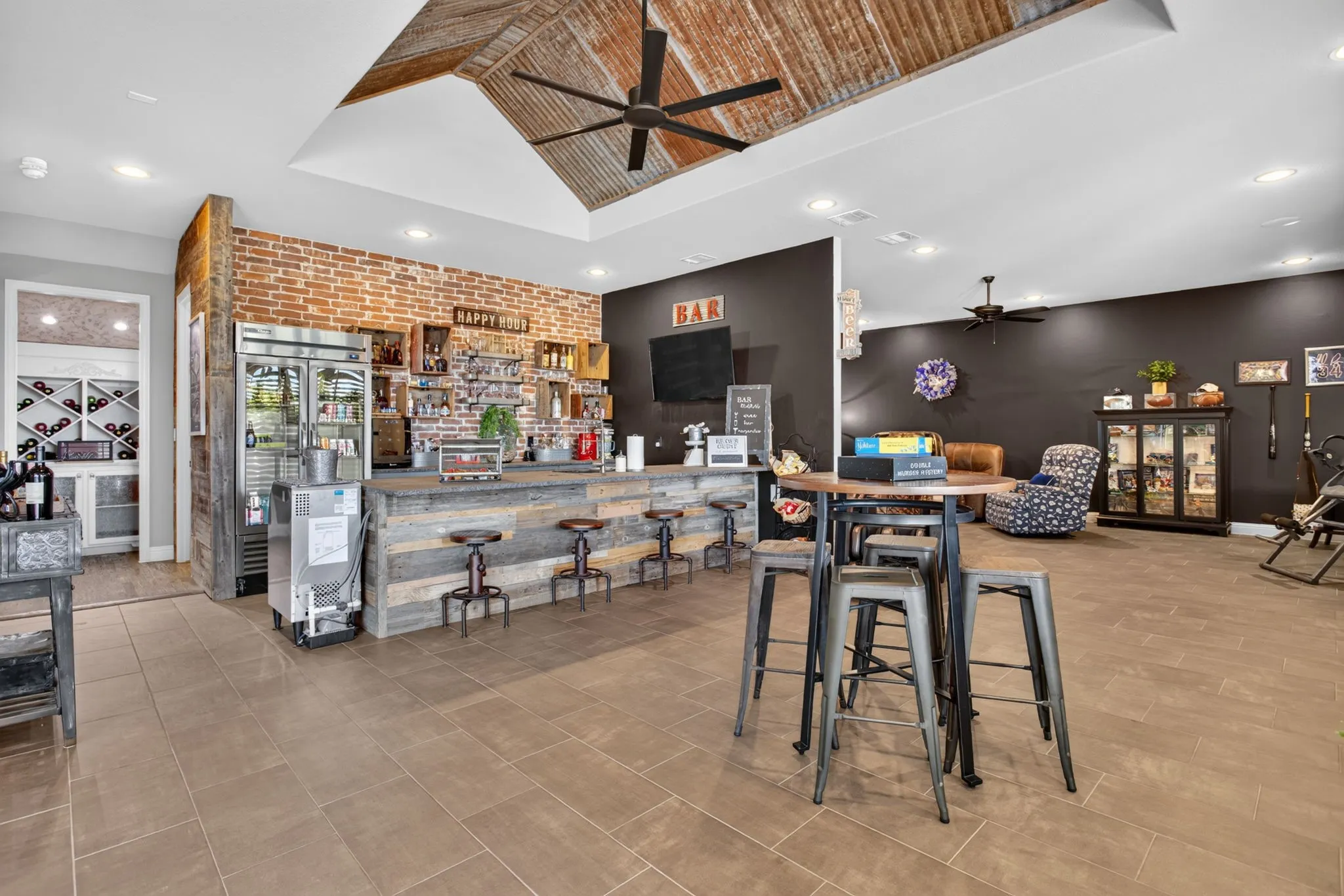 Gameroom has a bar with sink & commercial fridge and ample seating