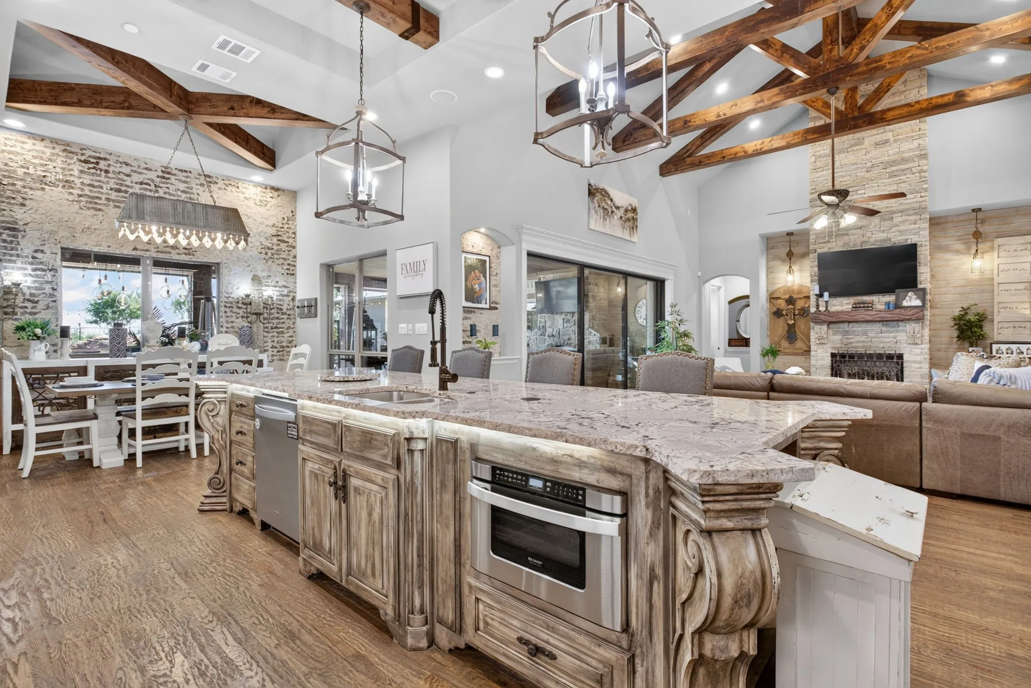 Expansive kitchen island featuring a granite countertop, built-in microwave, and integrated dishwasher