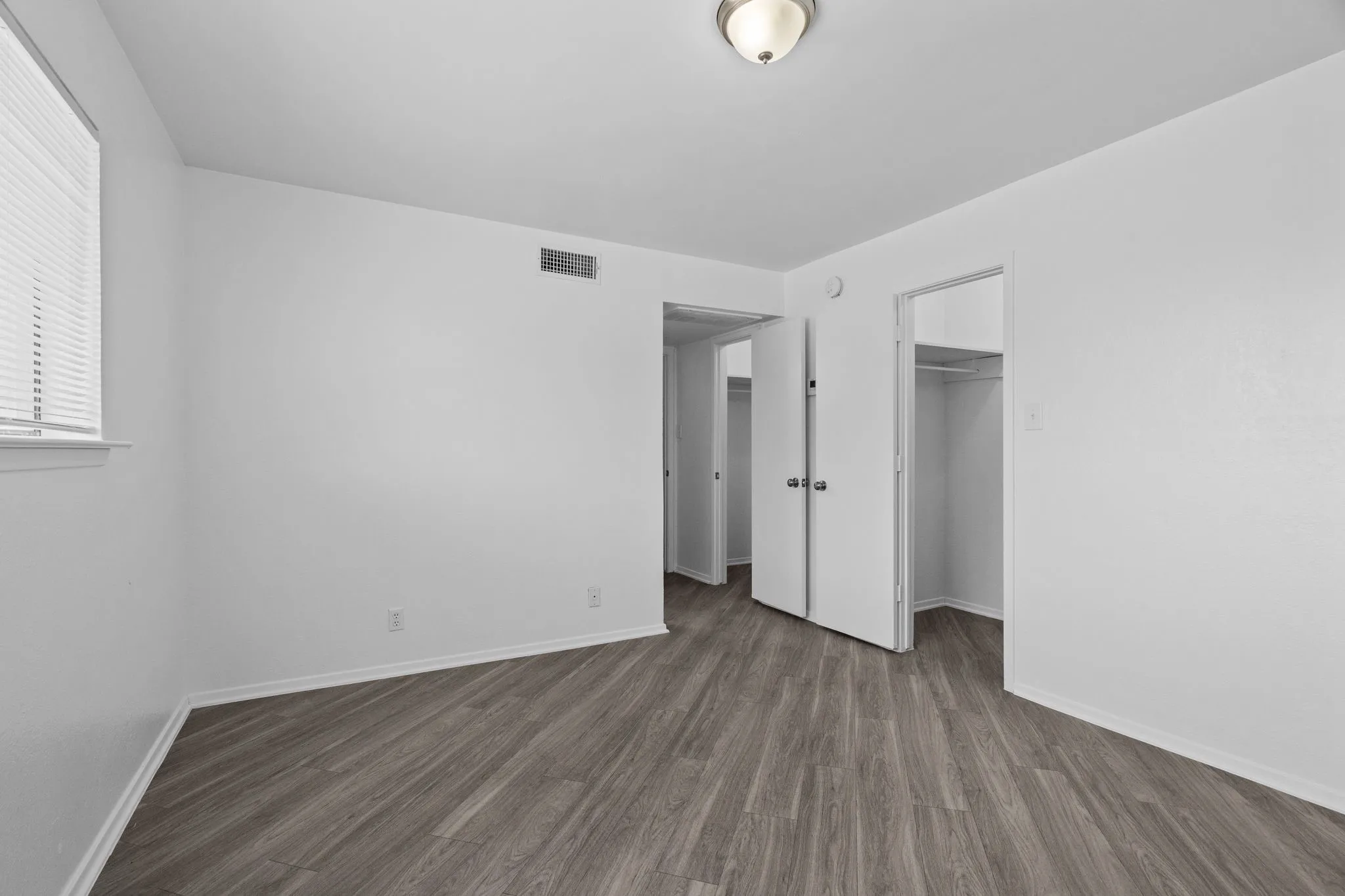 Bright interior space featuring wood-finish flooring, white baseboards, and white walls