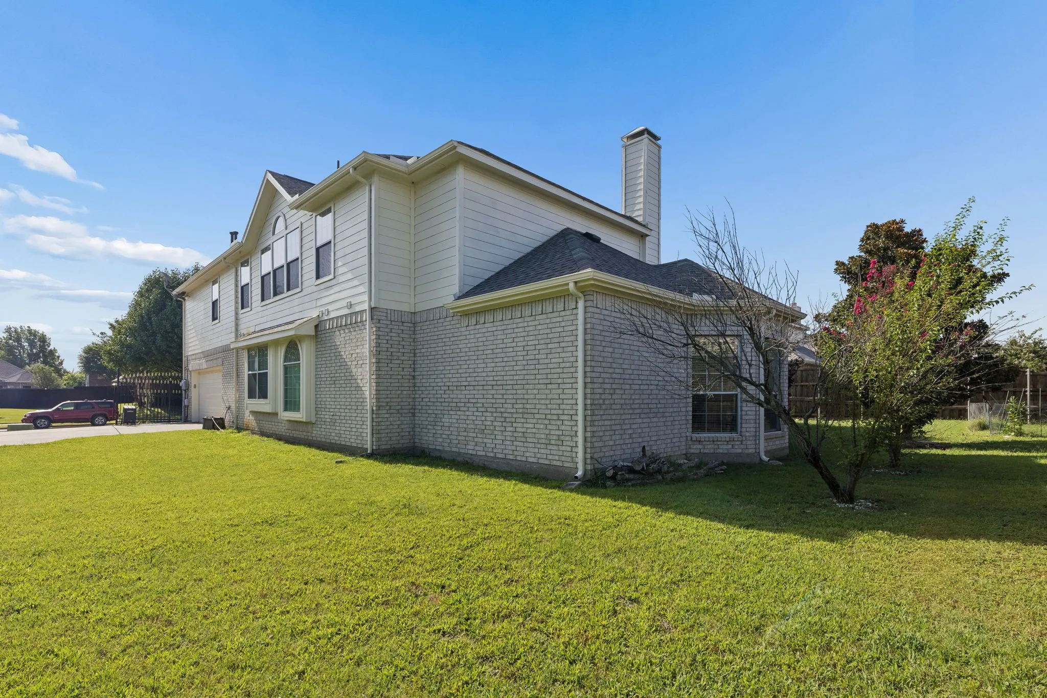 Spacious exterior featuring a two-story design with light-colored brick and siding