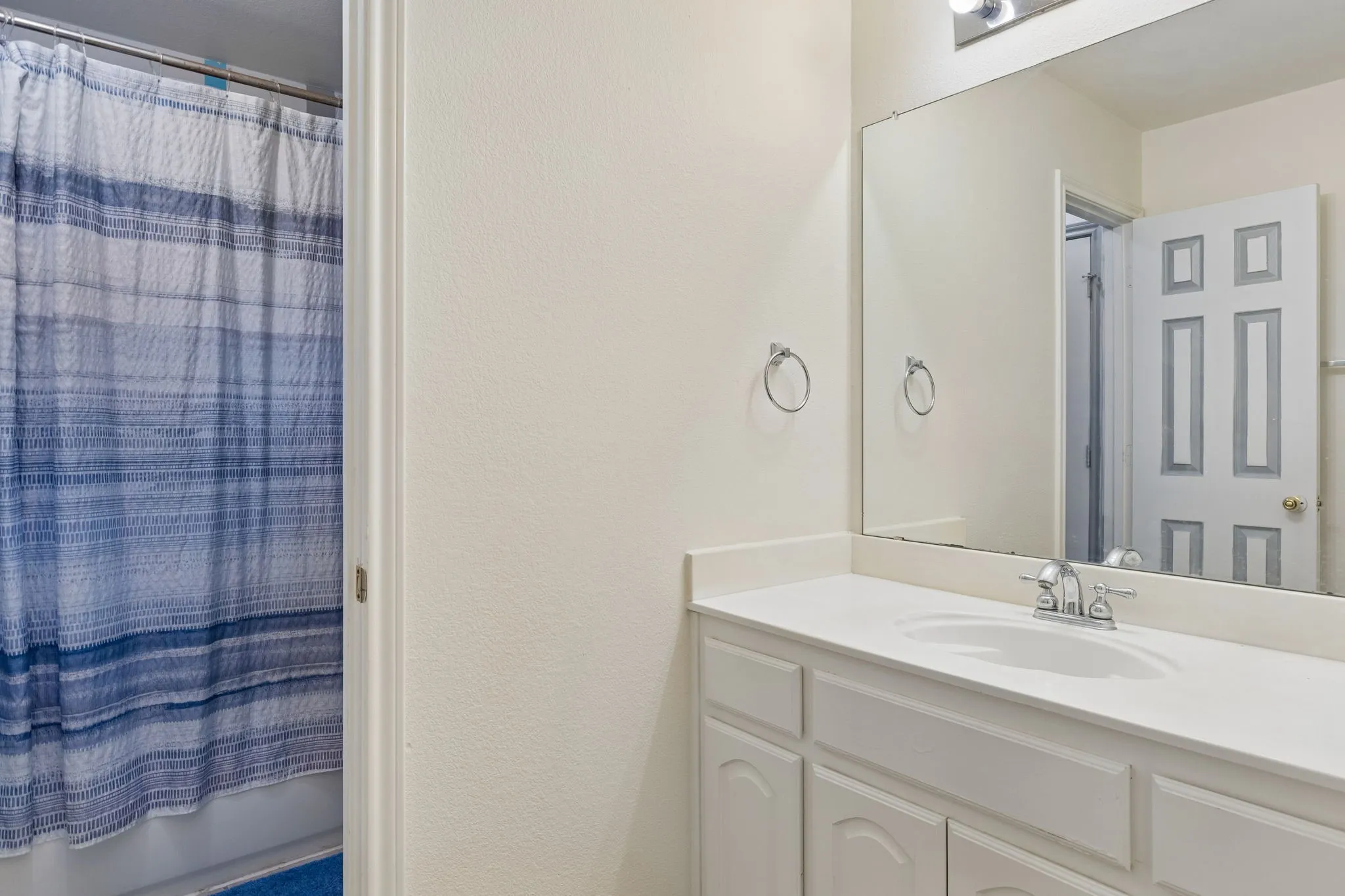 Bathroom featuring a vanity with a single sink, an integrated countertop, and cabinet storage