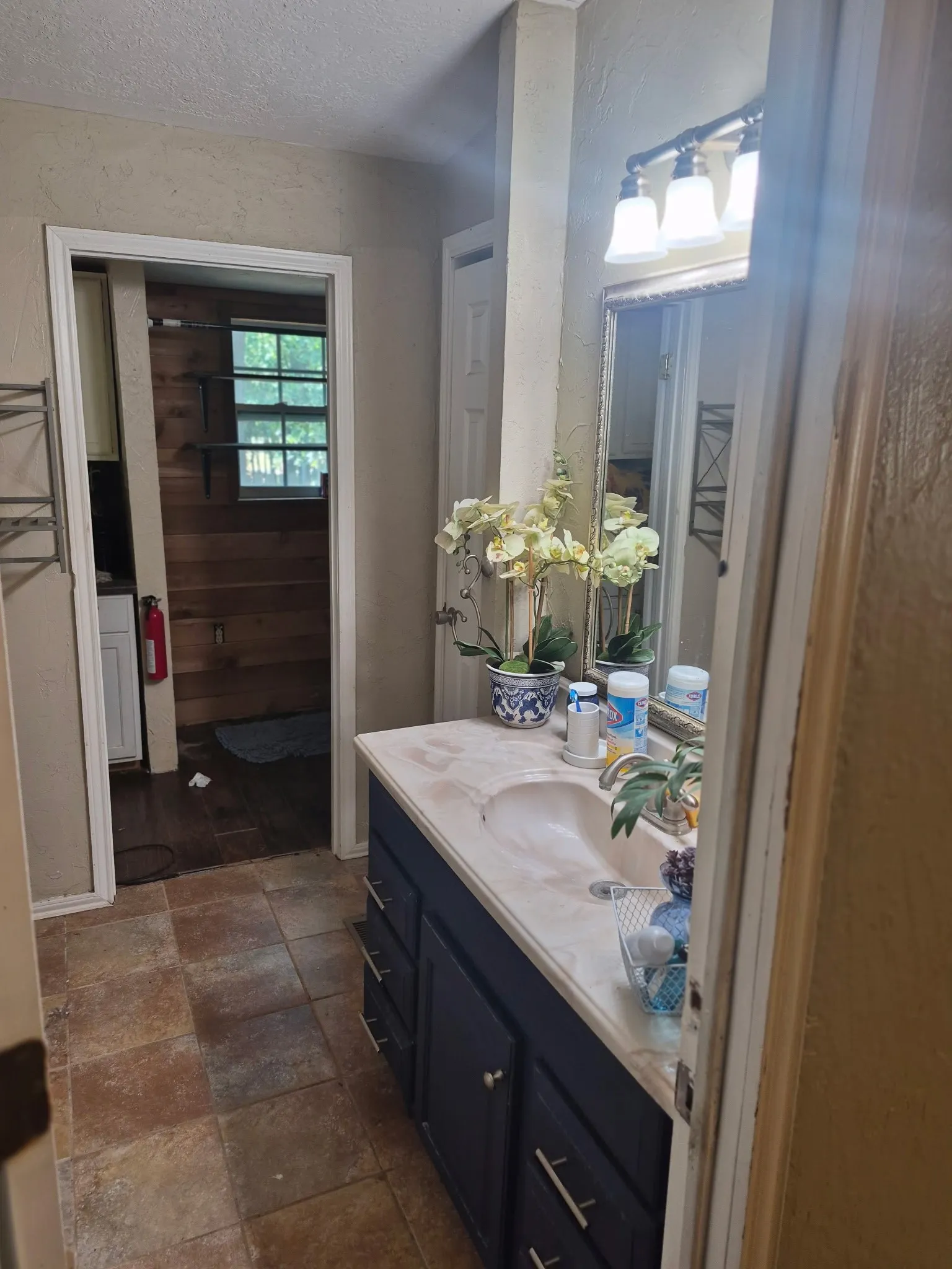 Vanity with integrated sink, dark wood-finish cabinetry, and brushed nickel hardware