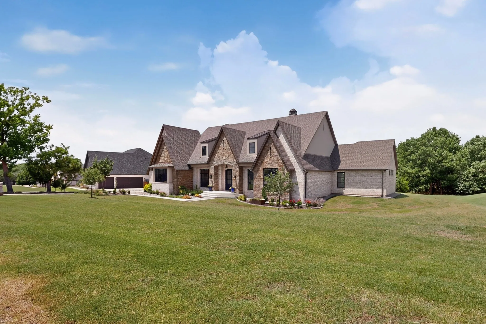 Angled view of front elevation, with steep gables and roof dormers.