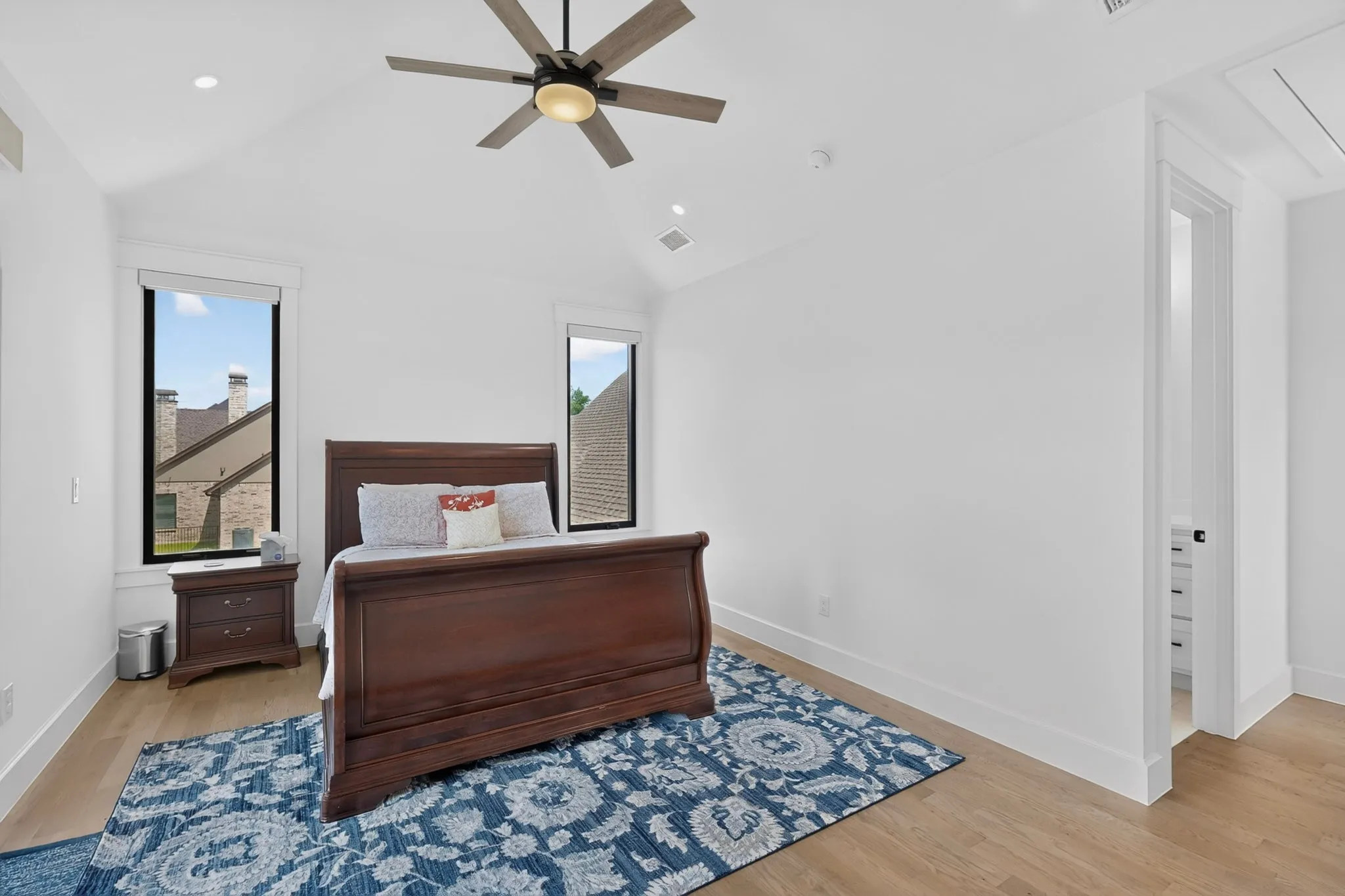 Vaulted ceiling bedroom featuring wood-finish flooring, recessed lighting, and a modern ceiling fan