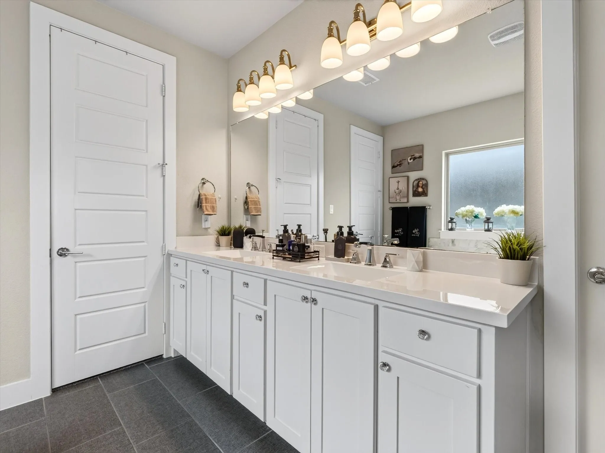 Double vanity featuring white shaker-style cabinetry and a light-toned countertop