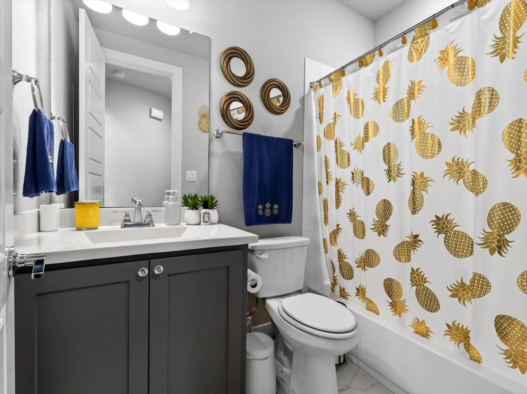 Bathroom featuring a built-in vanity with dark shaker-style cabinetry, a white countertop, and an integrated rectangular sink