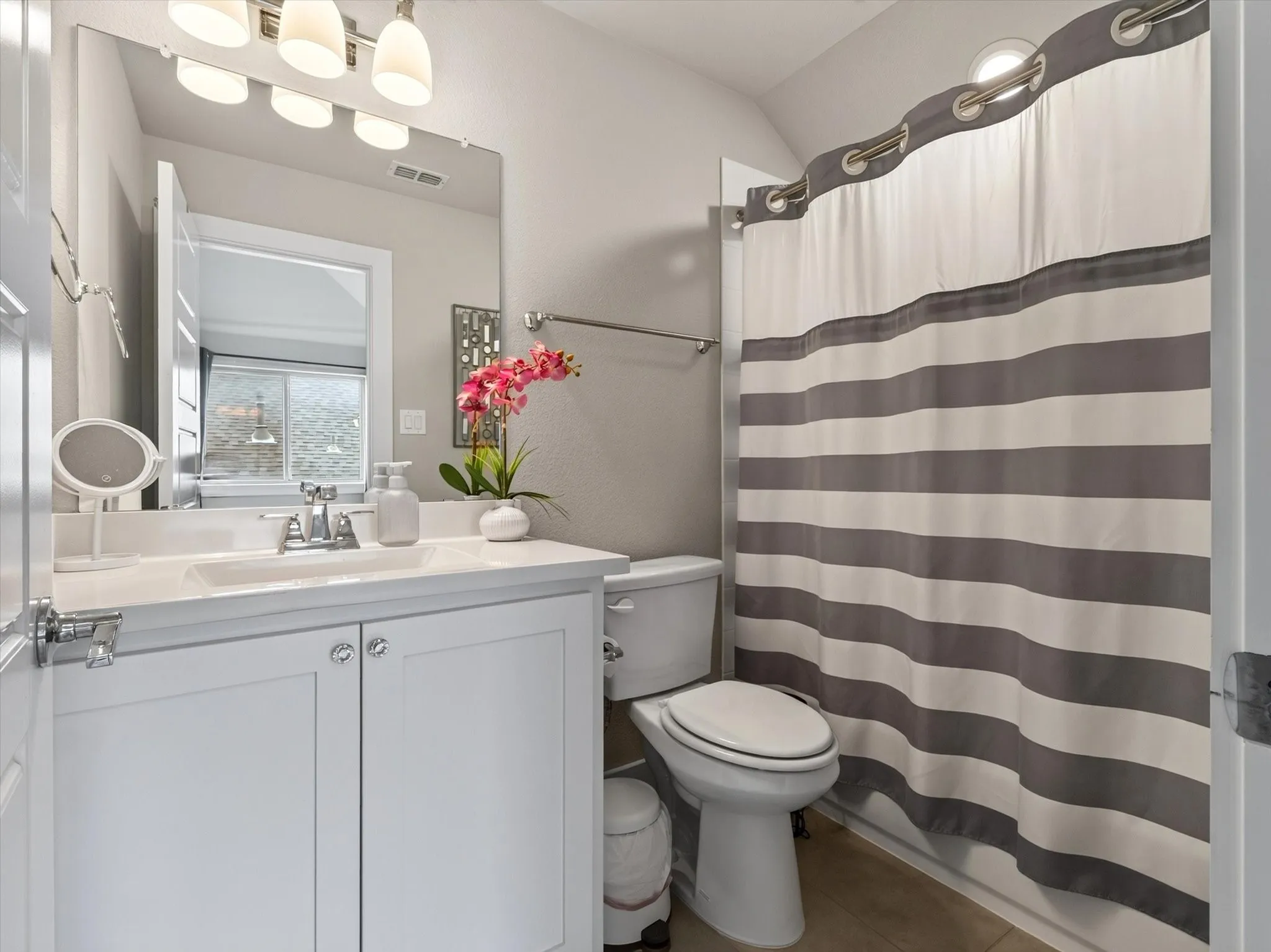 Contemporary bathroom featuring a white vanity with an integrated sink, polished chrome faucet, and a large wall-mounted mirror