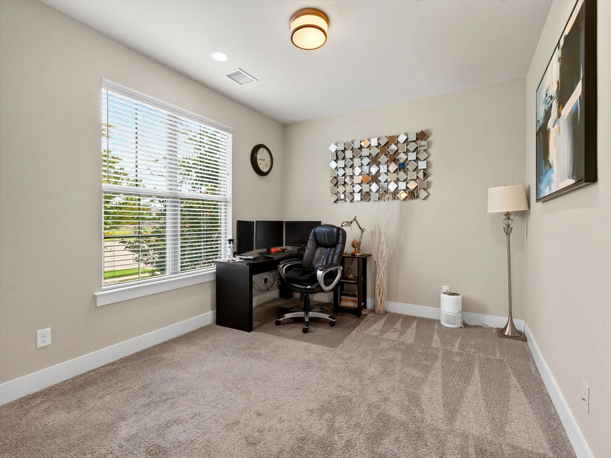 Spacious room featuring neutral carpeting, a large window with blinds, recessed lighting, and a contemporary ceiling fixture