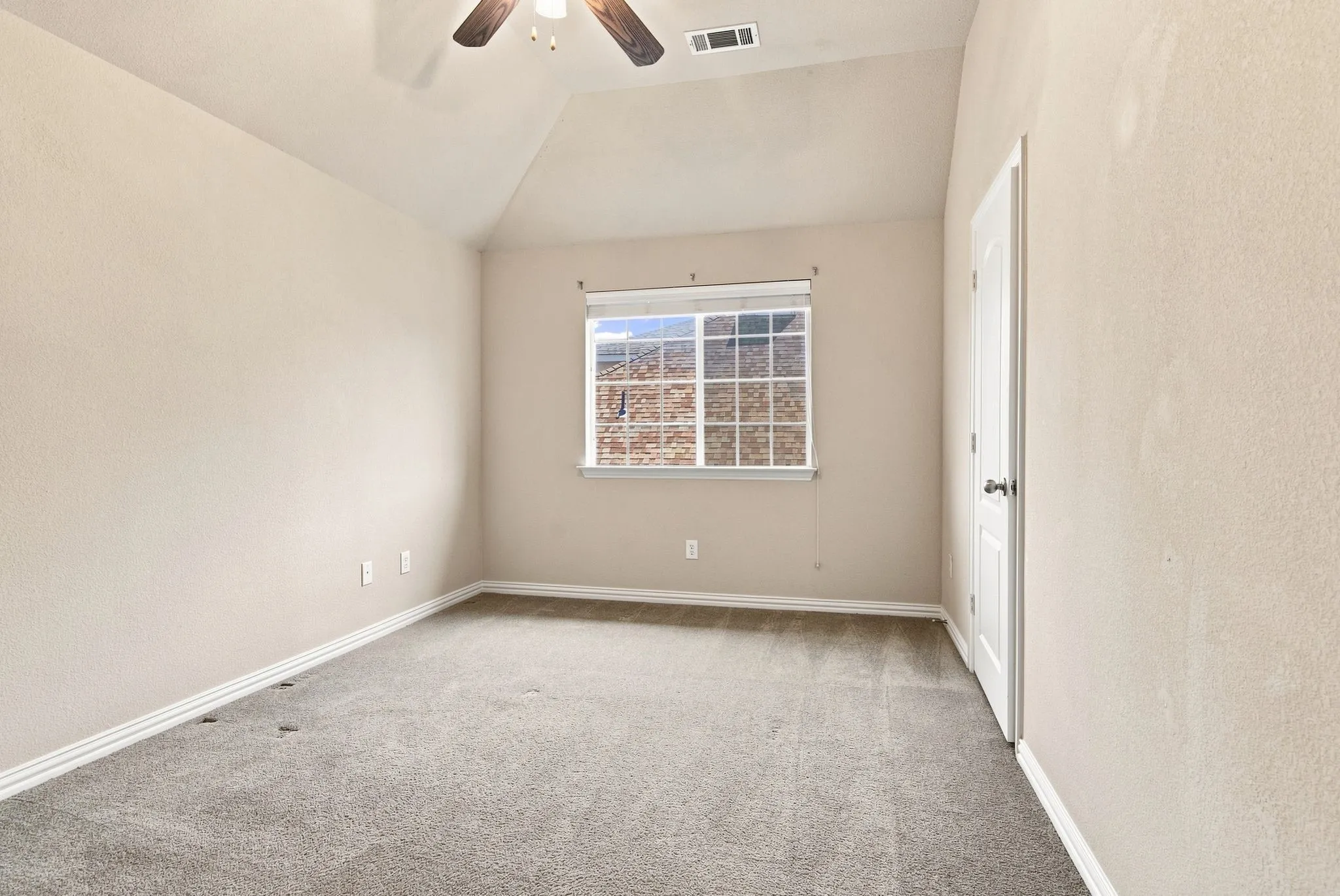 Carpeted room with a vaulted ceiling, a ceiling fan, and a window with white blinds