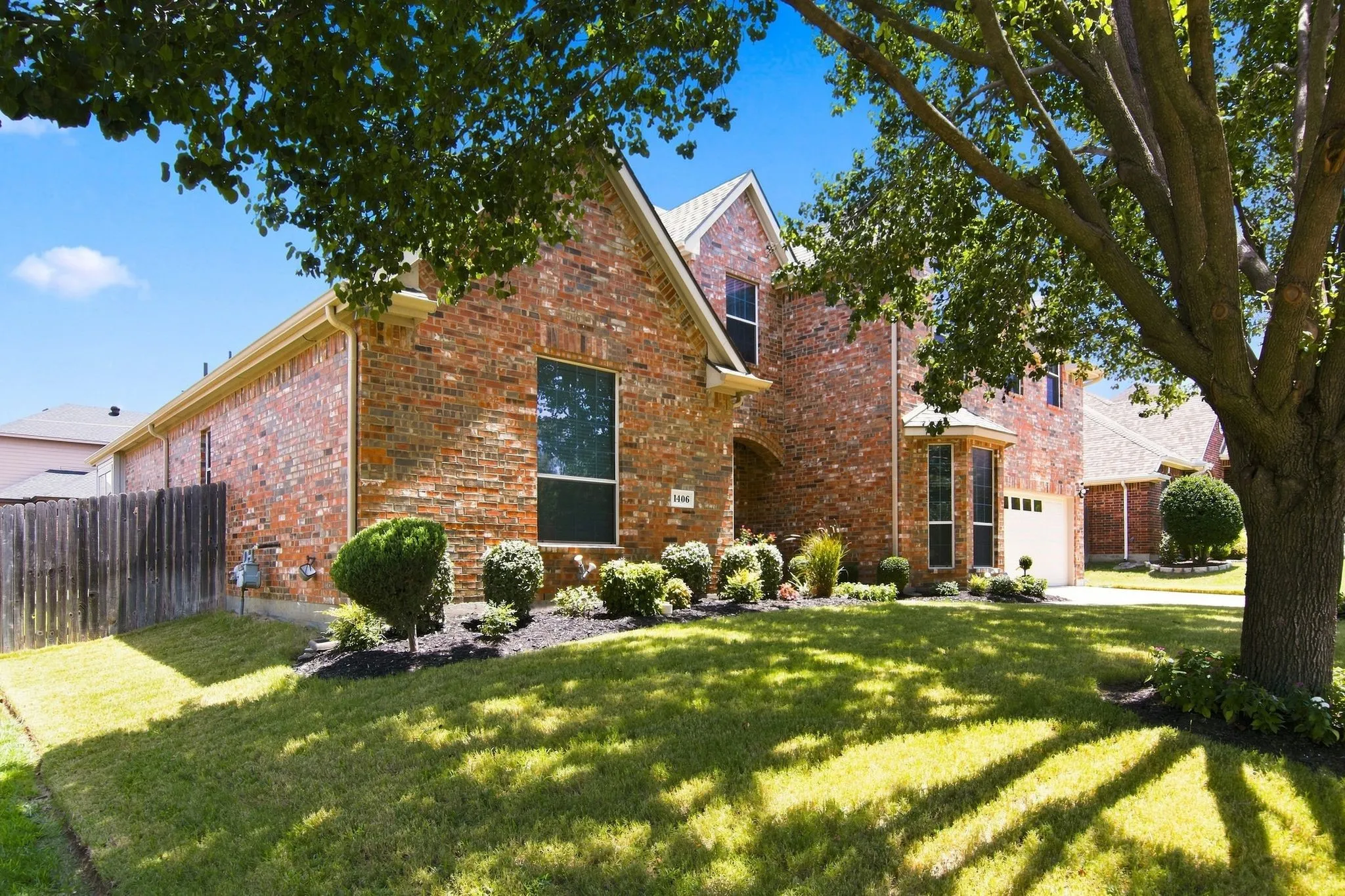 Brick exterior featuring a two-story design, an attached garage, a bay window, and a gabled roofline